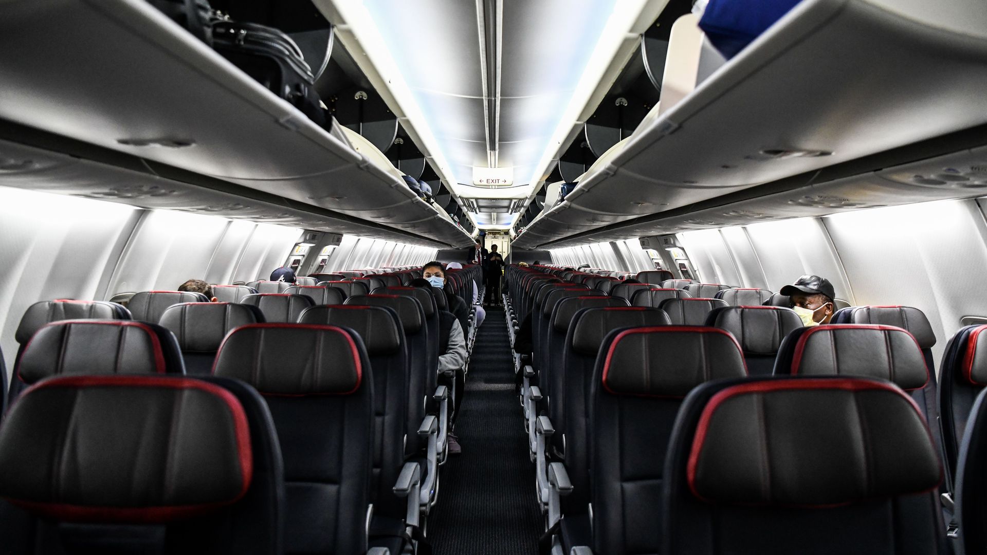 Image of socially distanced passengers wearing masks on a plane. 