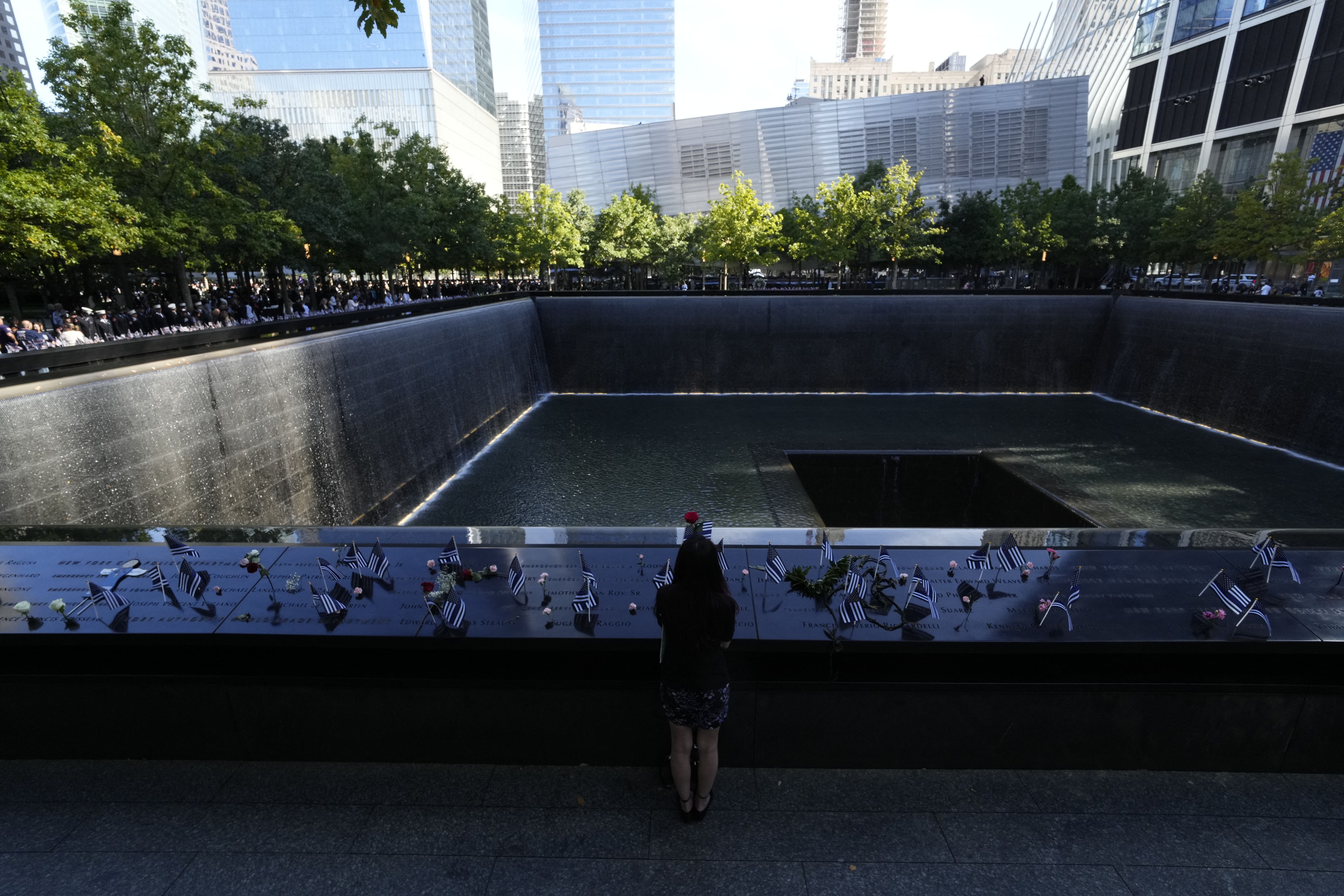 Mercedes arias pauses near the name of her father Joseph amatuccio at the South Tower reflecting pool of the 9/11 Memorial during the 23rd anniversary of the September 11 terror attack on the World Trade Center at Ground Zero, in New York City on September 11, 2024. (Photo by Adam GRAY / AFP) (Photo