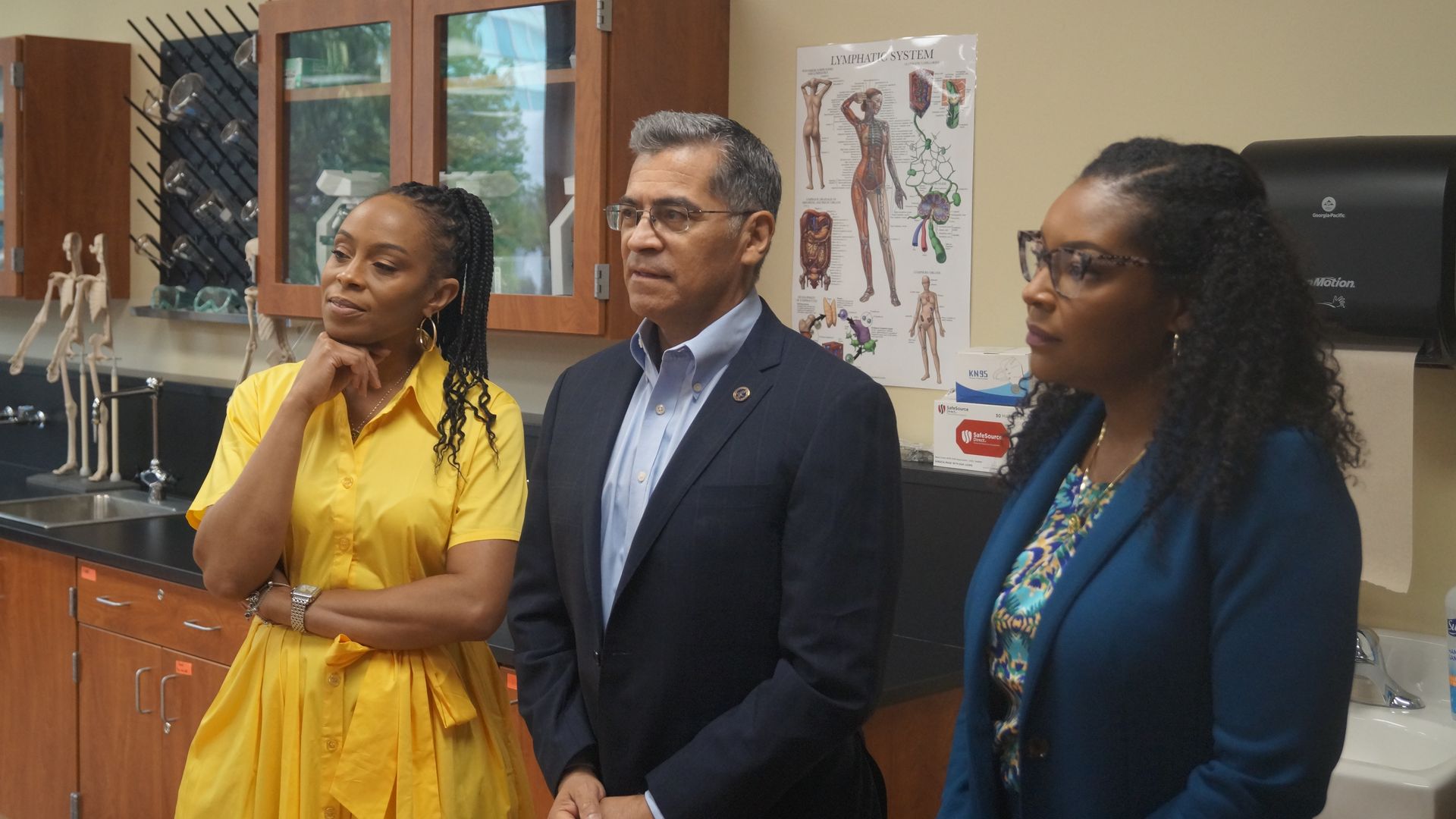 Secretary Xavier Becerra, flanked by Rep. Shontel Brown (L) and Rep. Emilia Sykes (R)