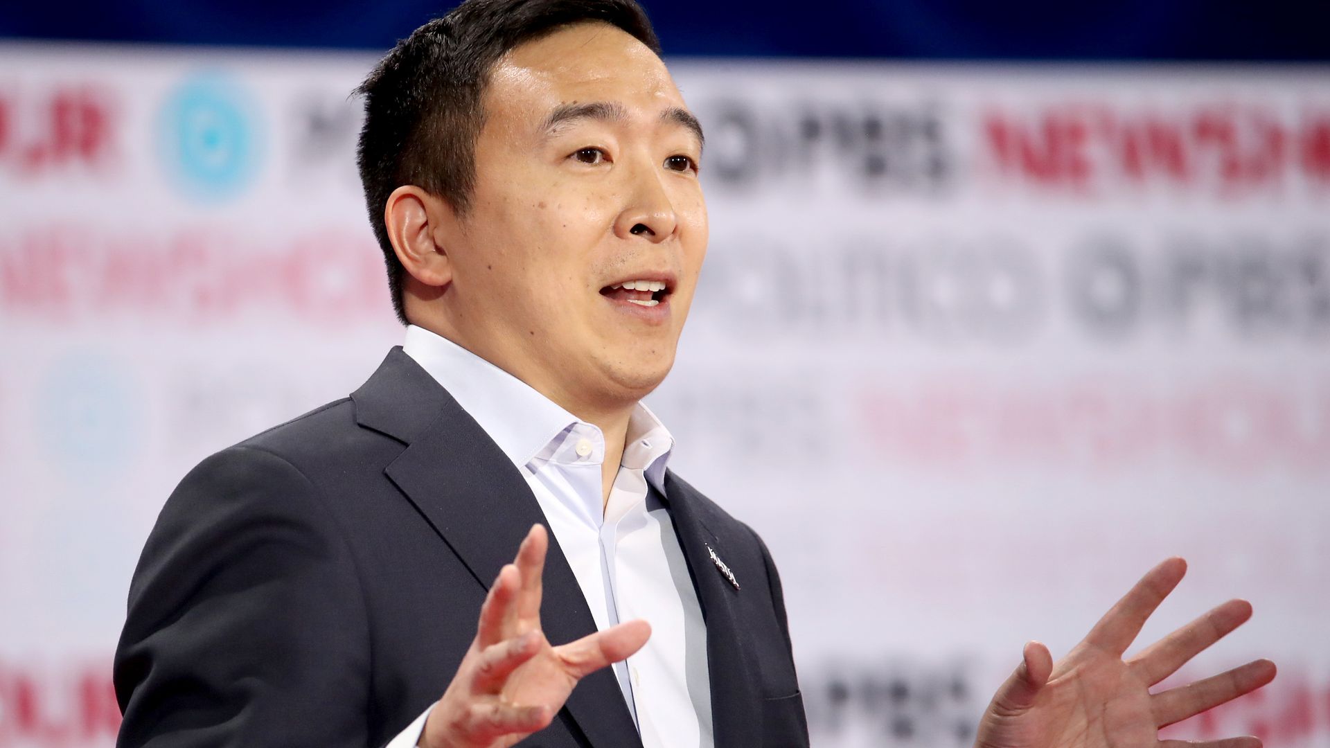 Andrew Yang speaks at a podium during a debate.