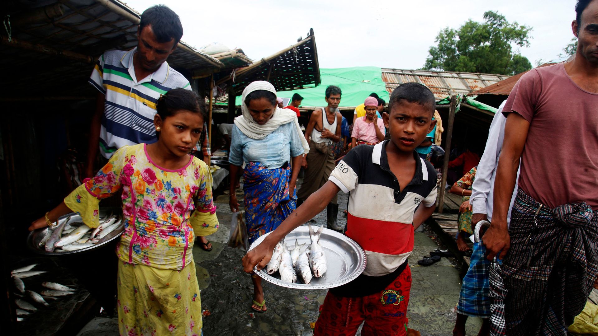 In this photo taken on July 4, 2021, internally displaced Rohingya walk at a market area in the Baw Du Pha IDP Camp in Sittwe in Myanmar's western Rakhine state.