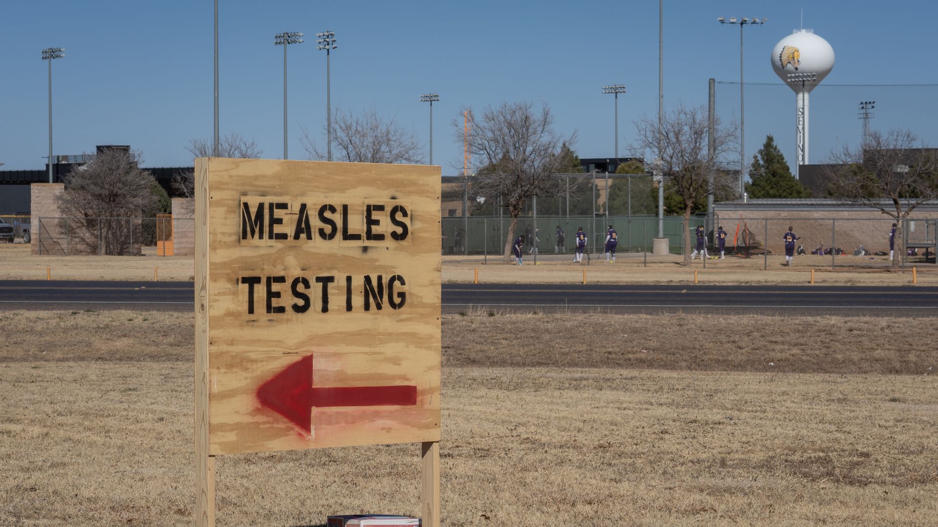 A wooden sign points to a measles testing site 