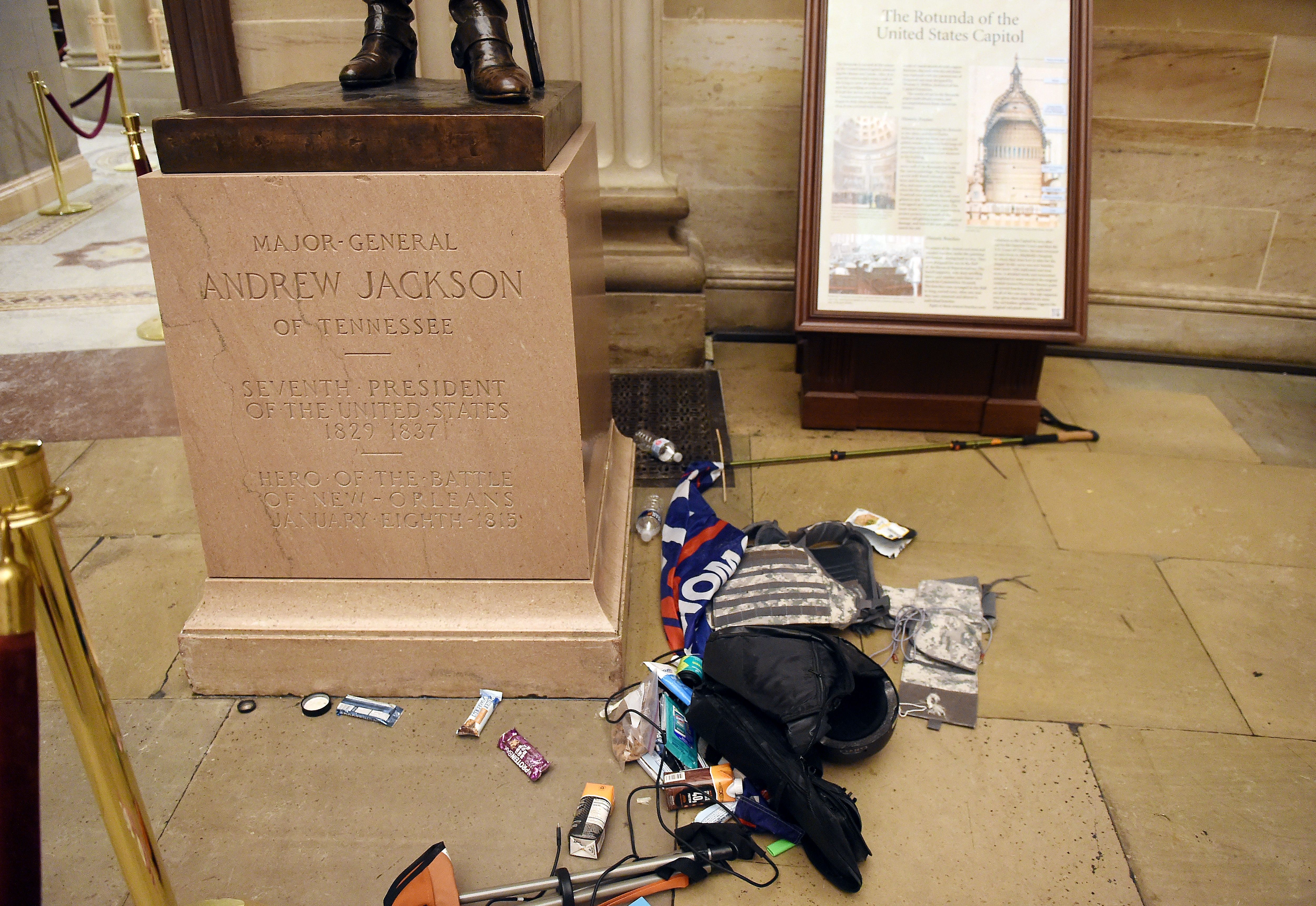 Trash next to a statue at the Capitol.