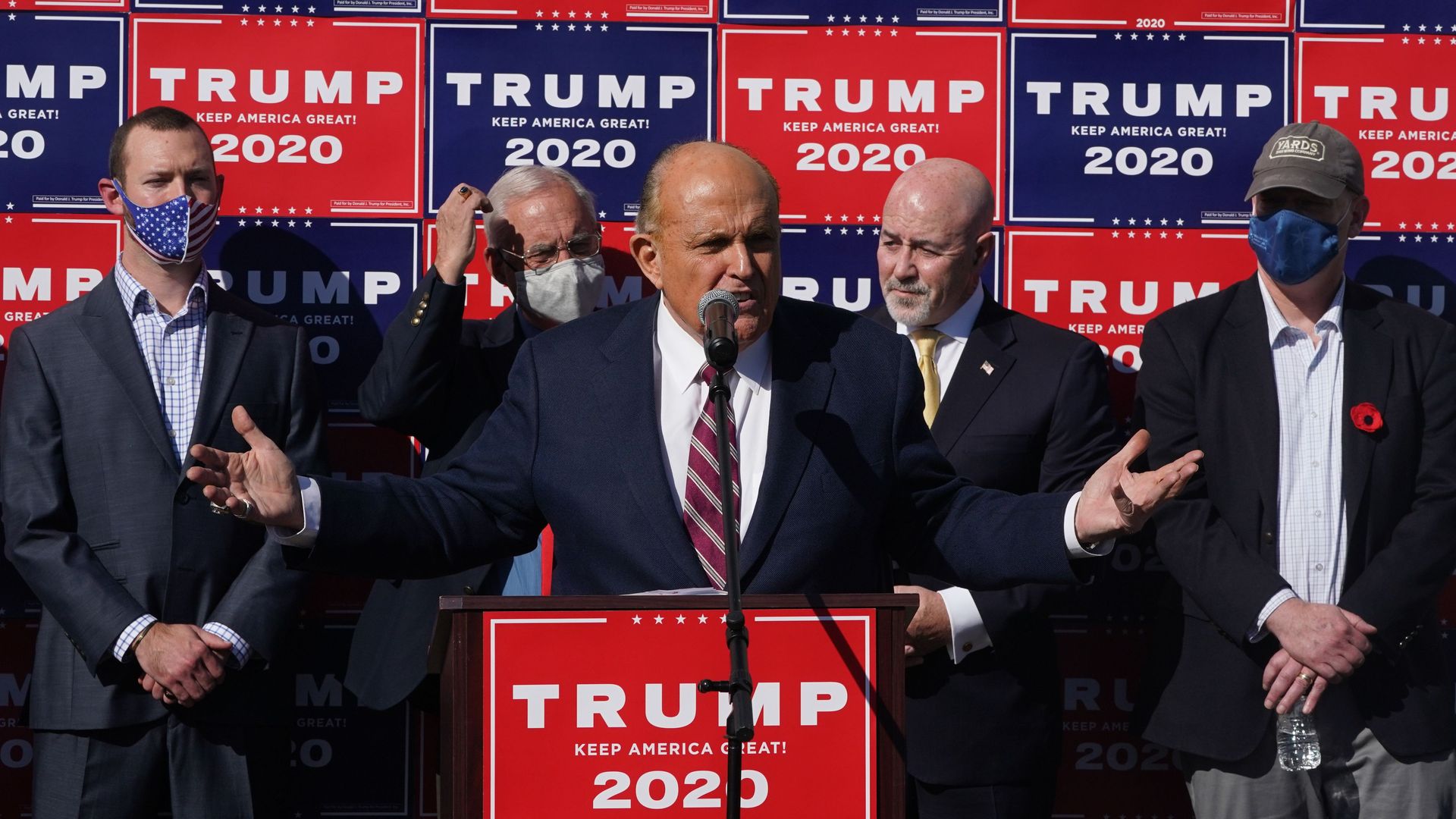 Photo of Rudy Giuliani speaking behind a podium at a Trump 2020 news conference 