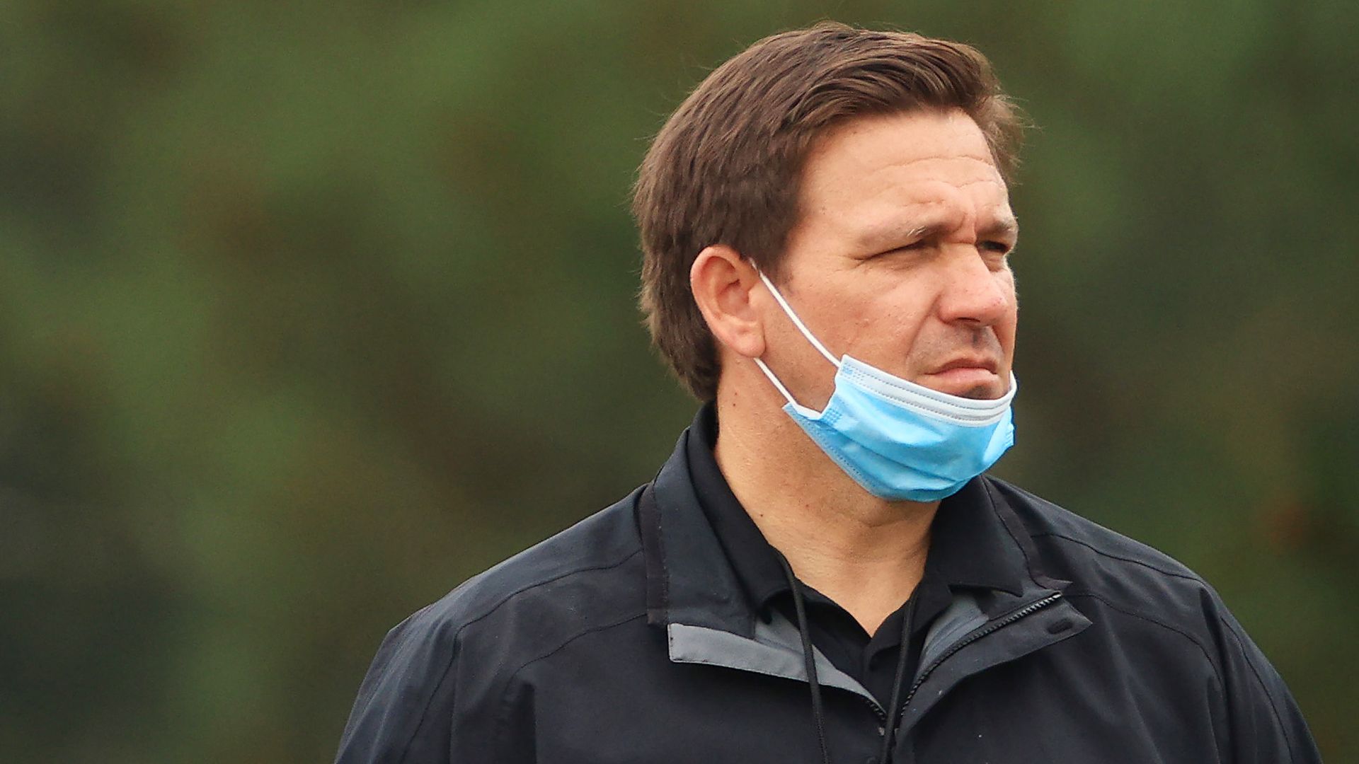 DeSantis wears a face mask around his chin 