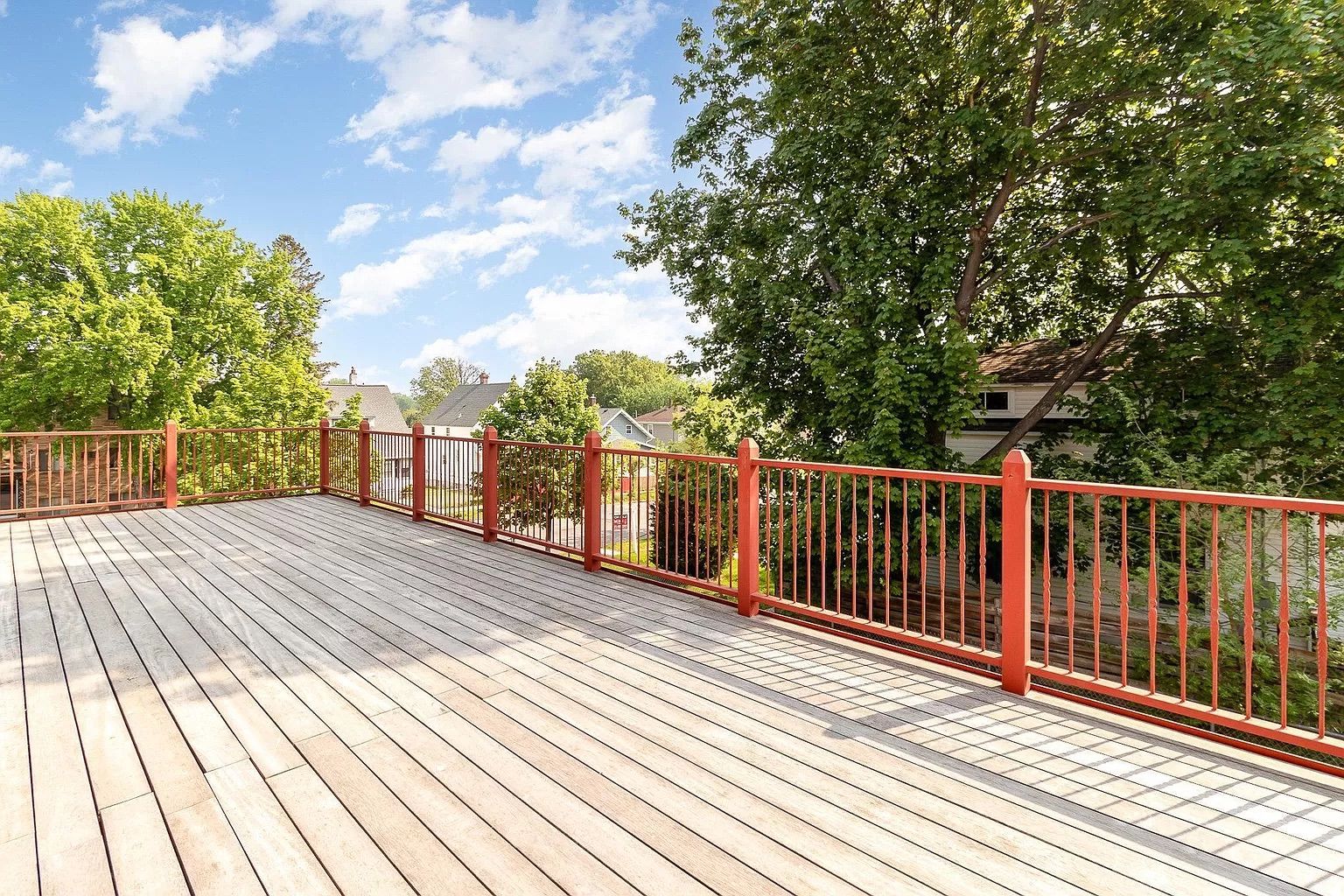 A large back deck with a red fence.