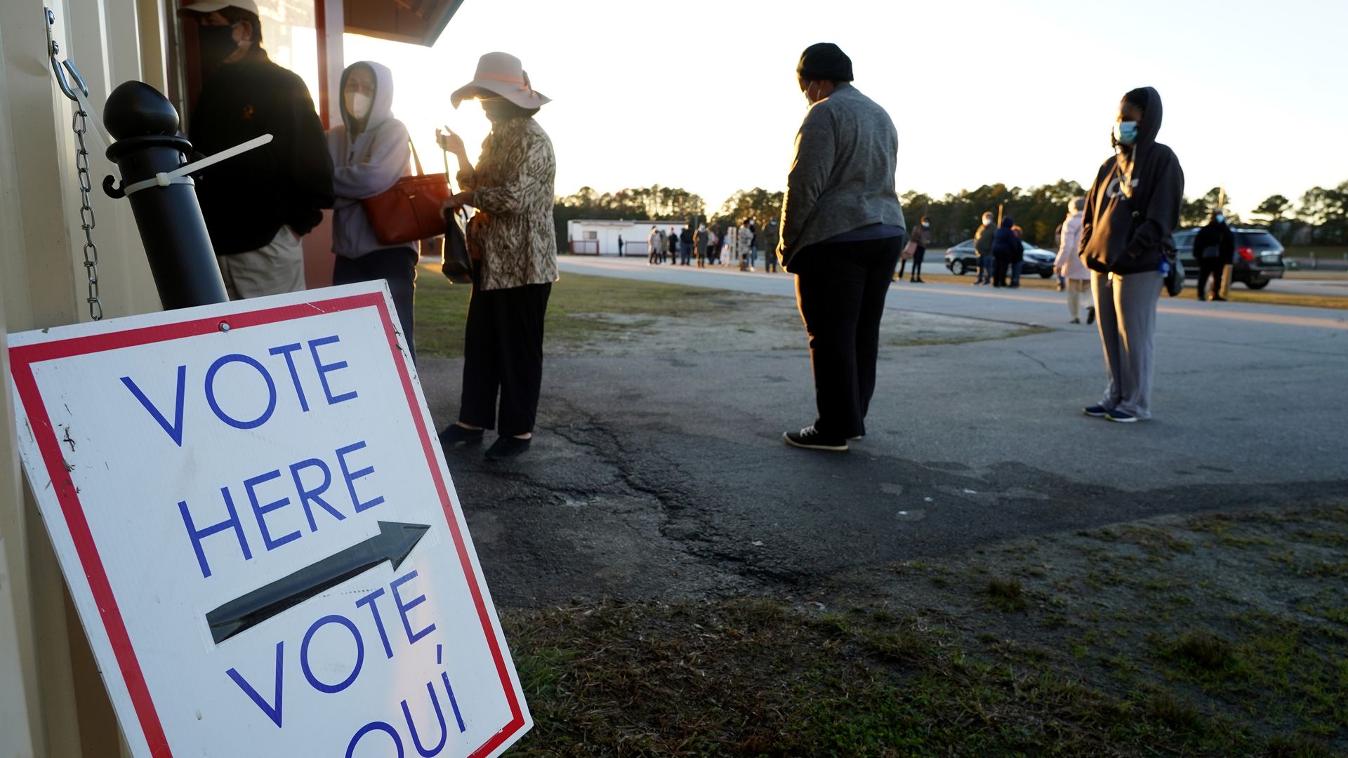 Voters stand in line to cast their ballots during the first day of early voting in the US Senate runoff at the Gwinnett Fairgrounds, December 14, 2020,