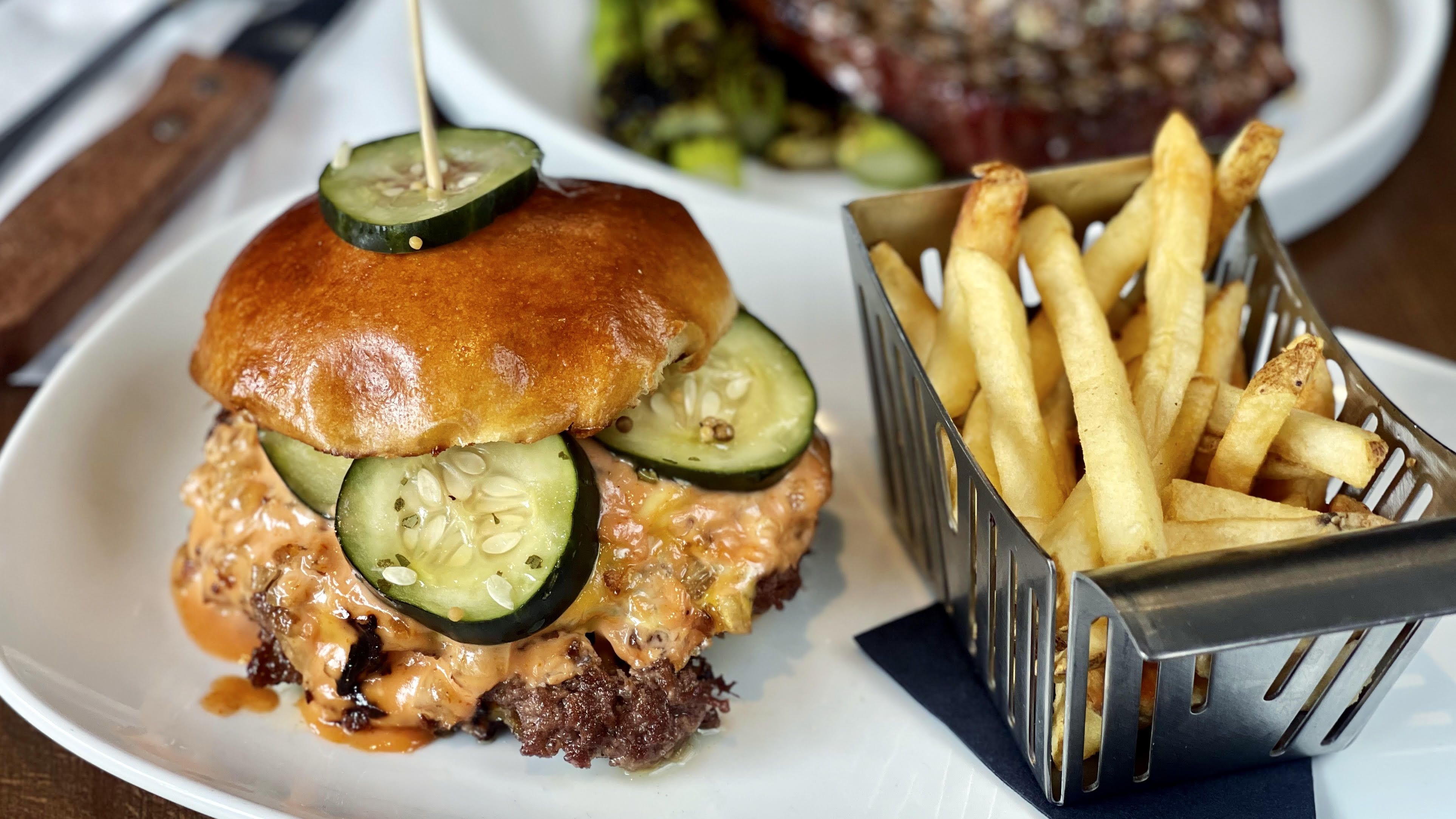 a burger and fries with cheese and pickles