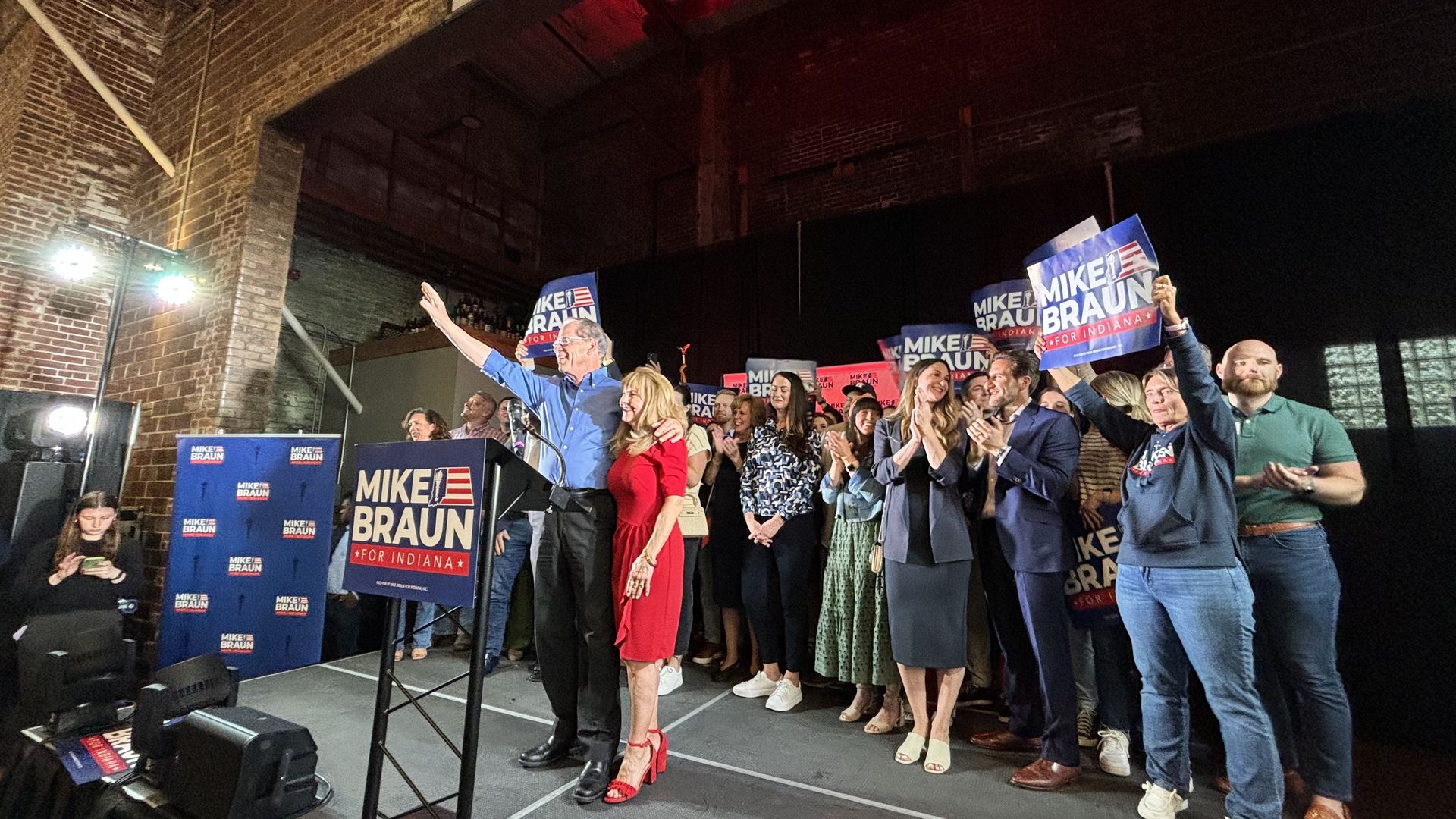 Mike Braun hugging his wife on a stage in front of supporters