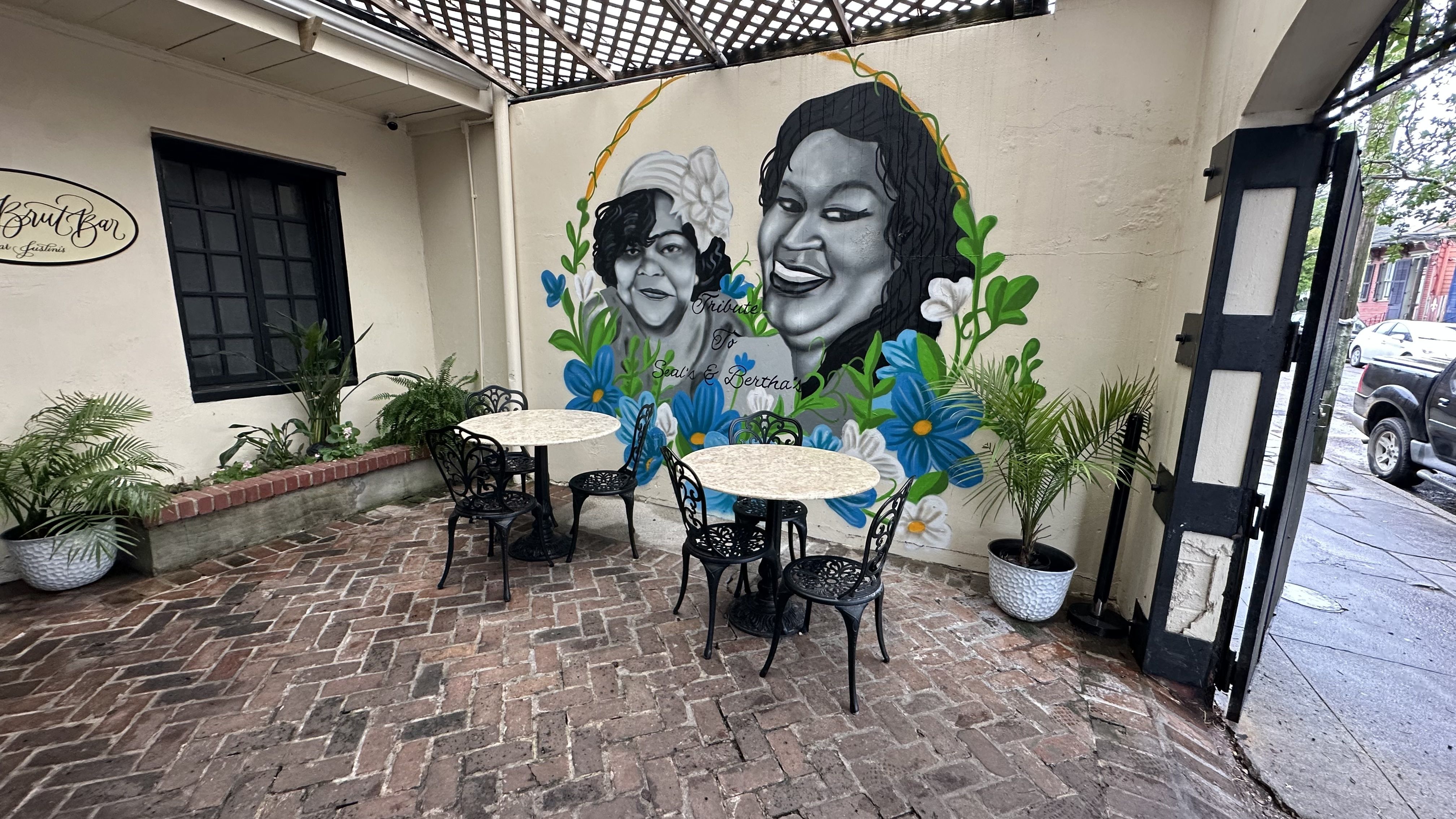 A mural of two women smiling in a courtyard.