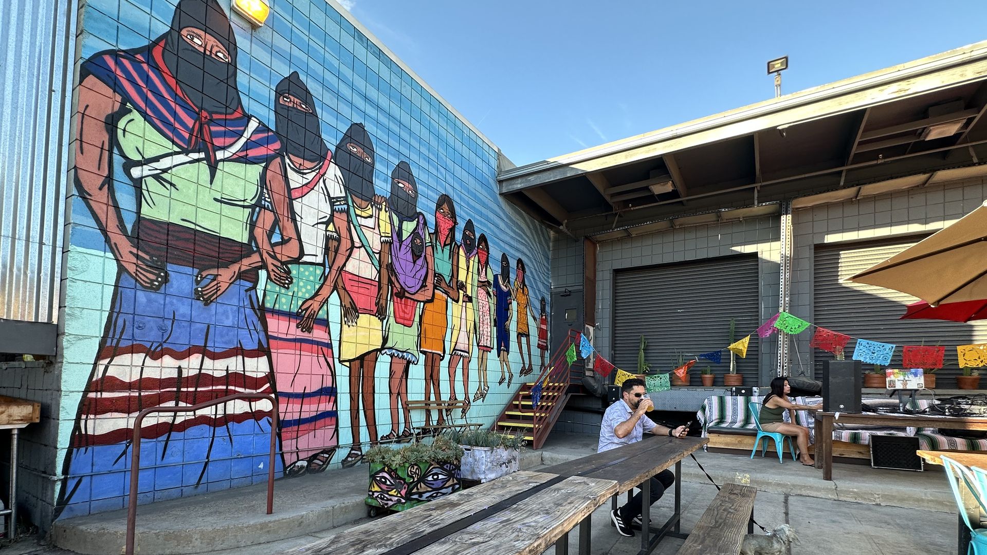 A mural at Mujeres Brew House in San Diego sits next to a flight of craft beer.