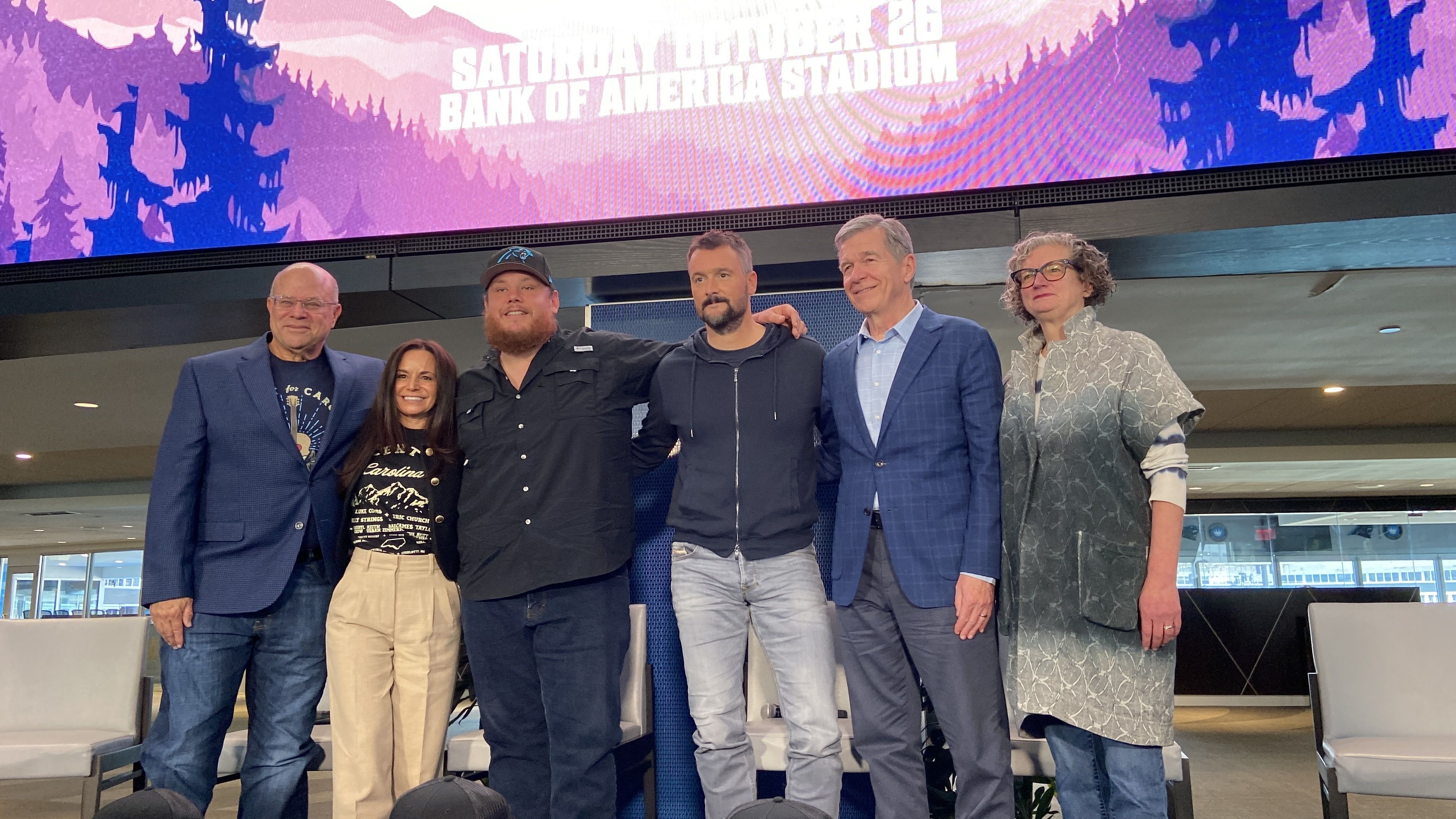 From left: Concert for Carolina press conference with David and Nicole Tepper (owners of the Carolina Panthers and Charlotte FC), country stars and western North Carolina natives Luke Combs and Eric Church, N.C. Gov. Roy Cooper and Vic Isley (president & CEO of Explore Asheville).