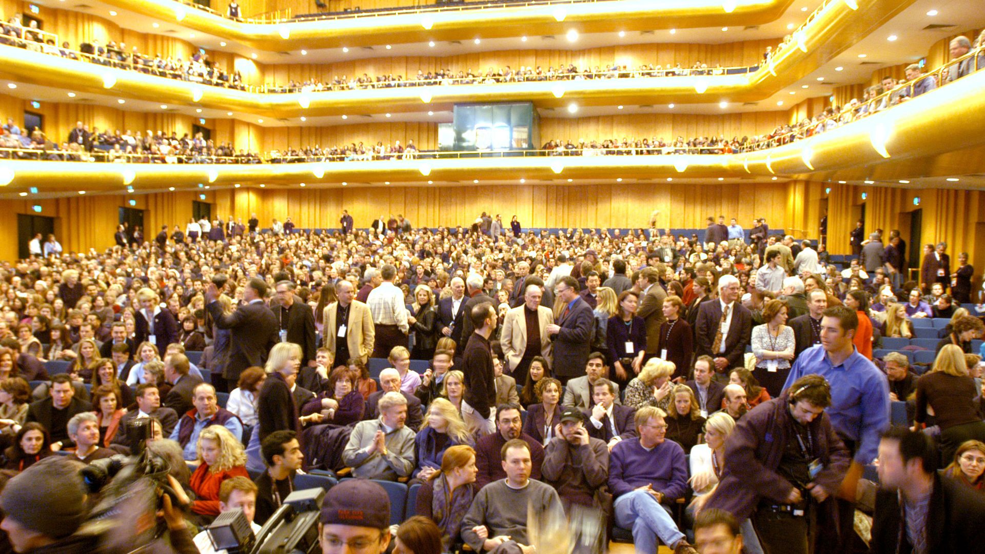 A crowd takes their seats inside a concert hall.