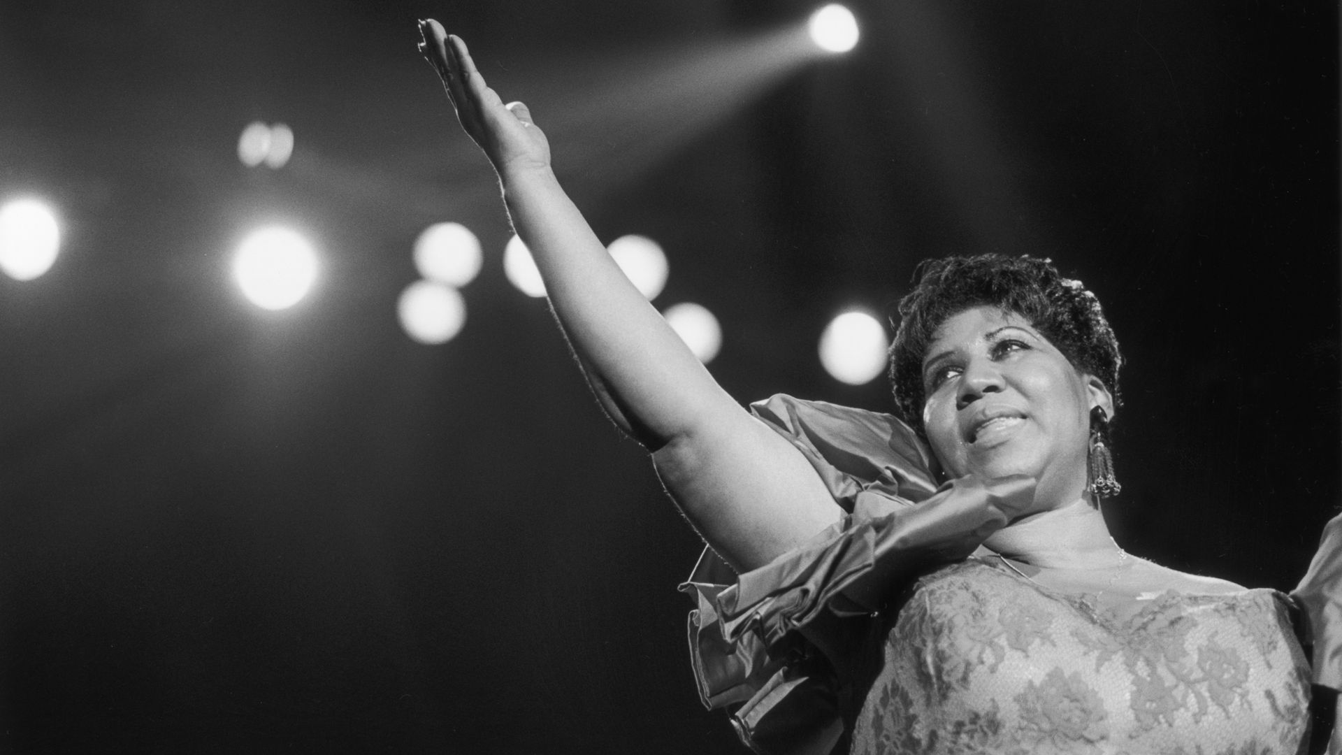 A black-and-white photo of Aretha Franklin singing.