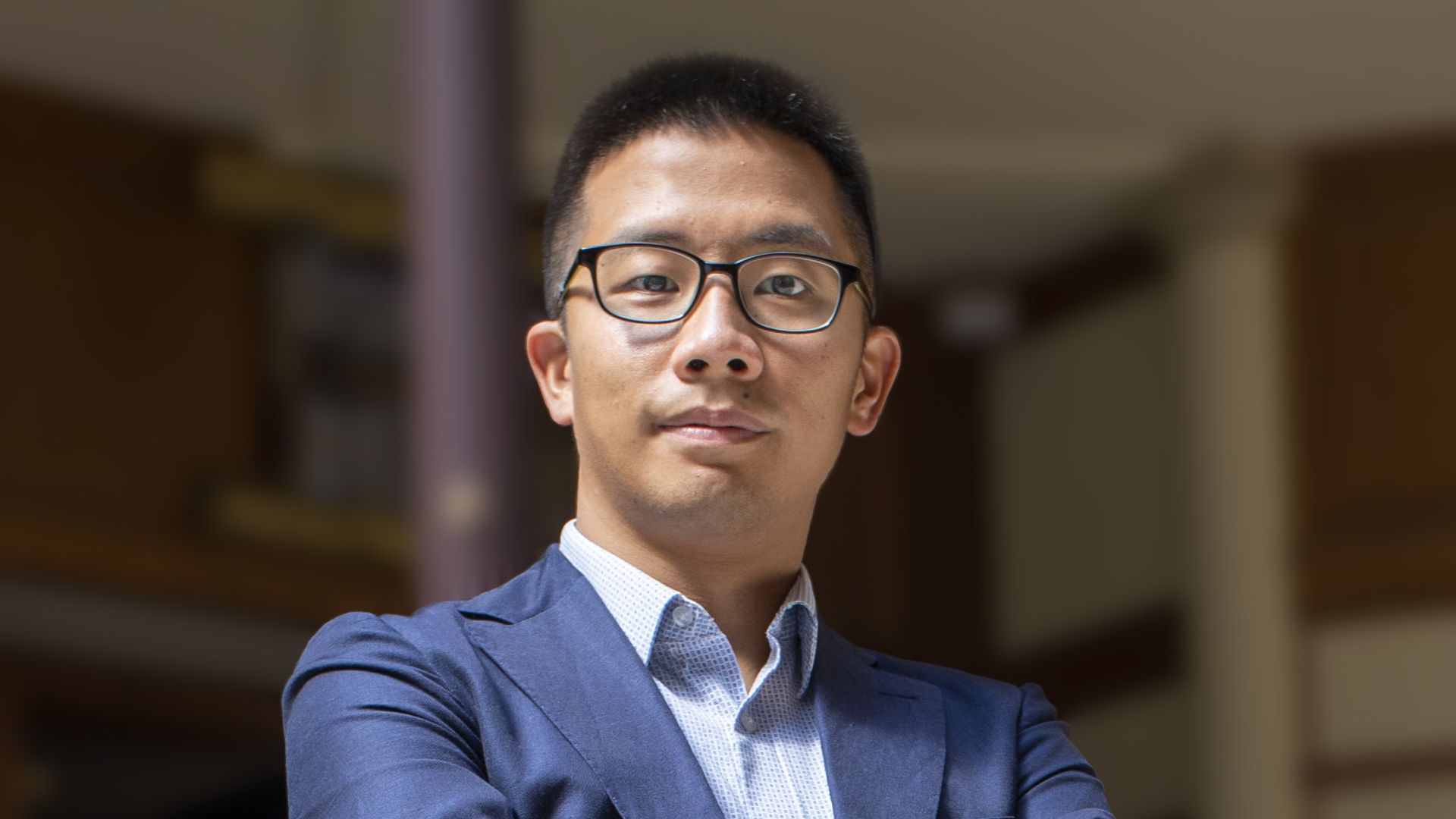 Cleveland law professor Matthew Ahn stands with his arms crossed posing for a photo.