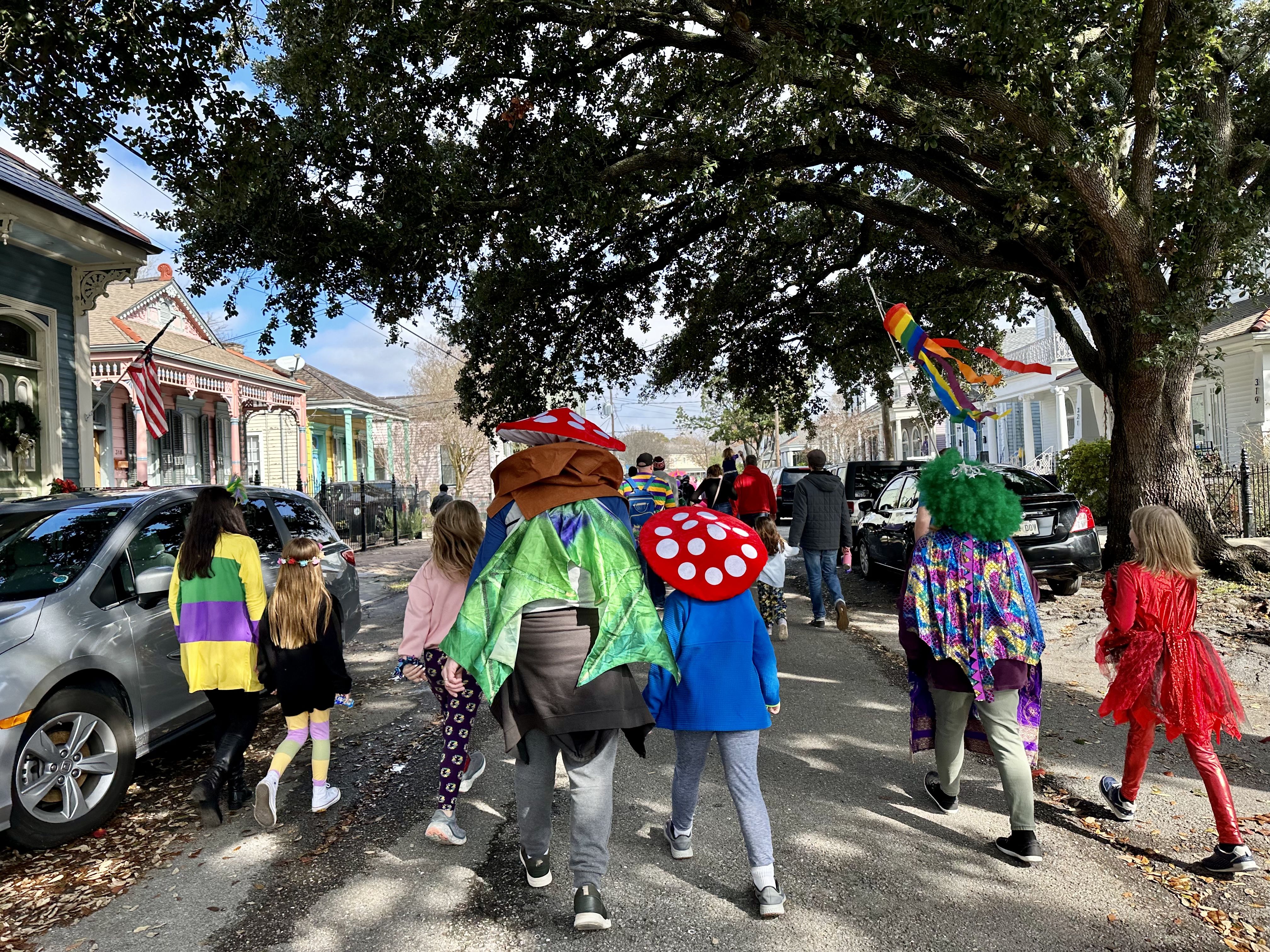 Photo shows children in costume walking in the Krewe of Confetti Kids parade in Algiers Point in New Orleans.