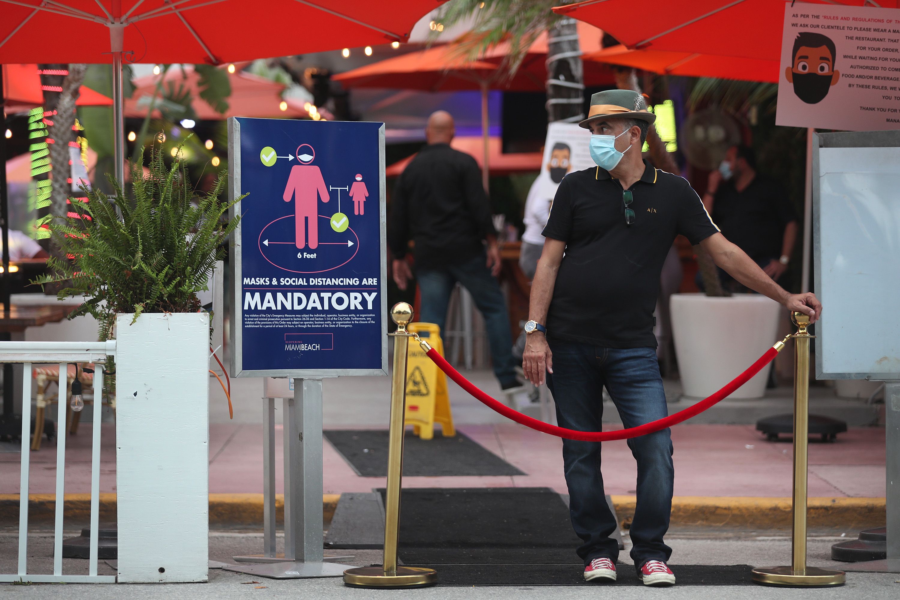 A restaurant host at the entrance of the restaurant to turn customers away as a curfew from 8pm to 6am is put in place on July 18, 2020 in Miami Beach, Florida. 