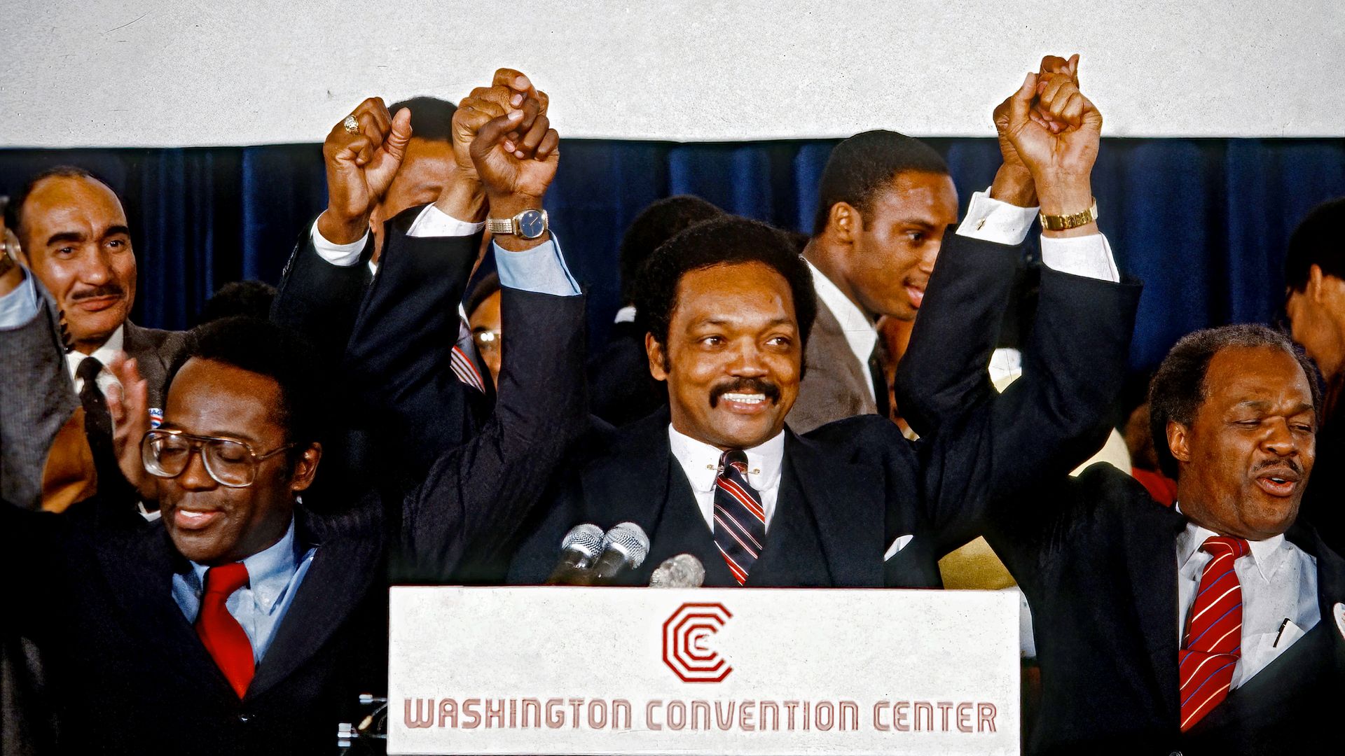 Jesse Jackson is photographed gripping the hand of Marion Barry as they celebrate at the Washington Convention Center