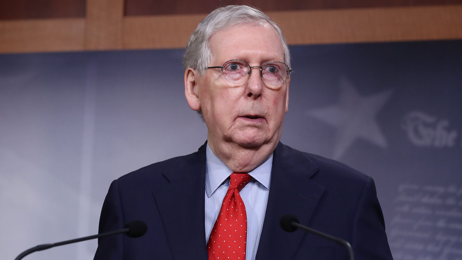Mitch McConnell looks to the left while standing at the podium