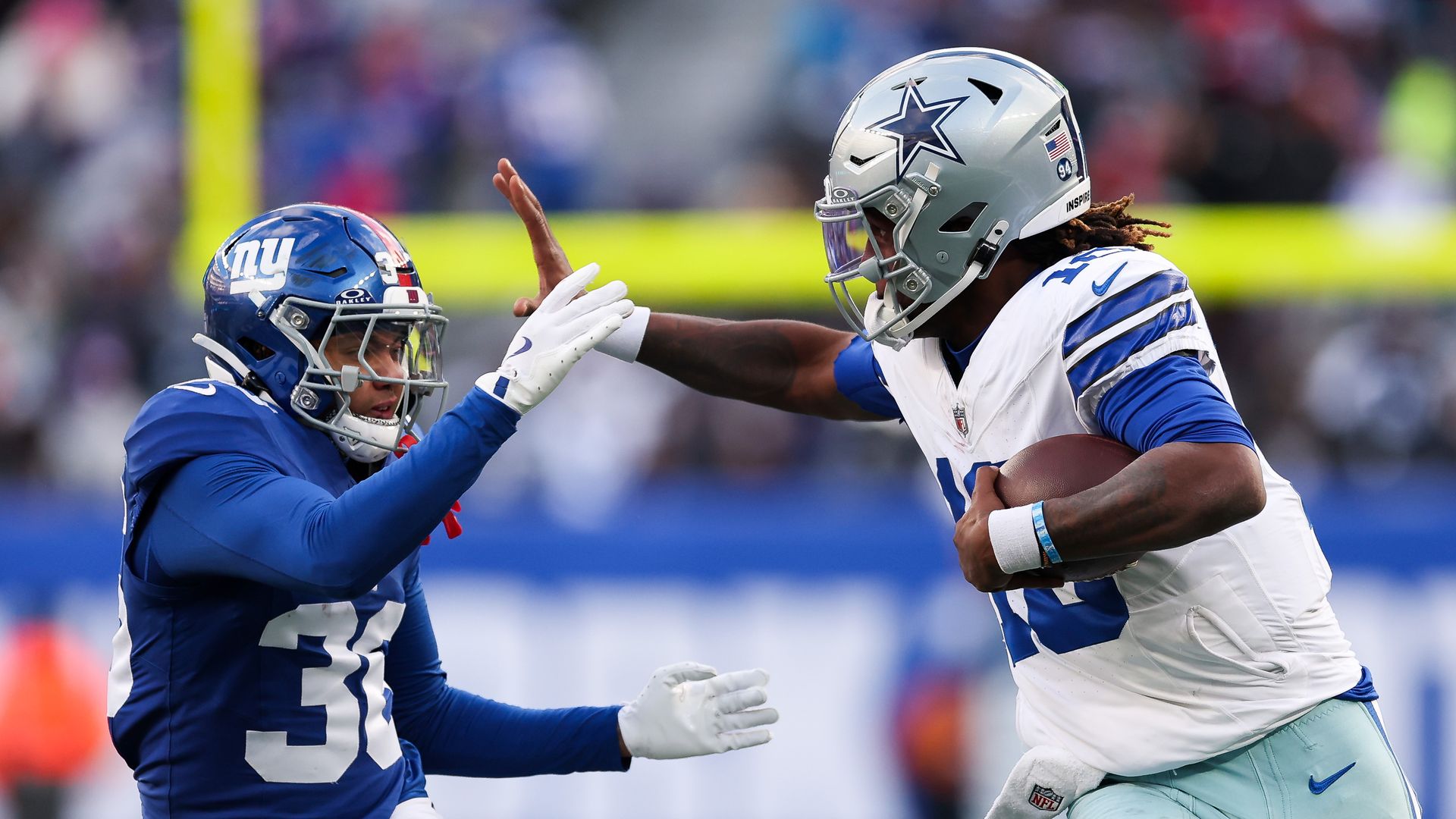 Joe Milton III #10 of the Dallas Cowboys runs the ball against Devin Singletary #26 of the New York Giants 