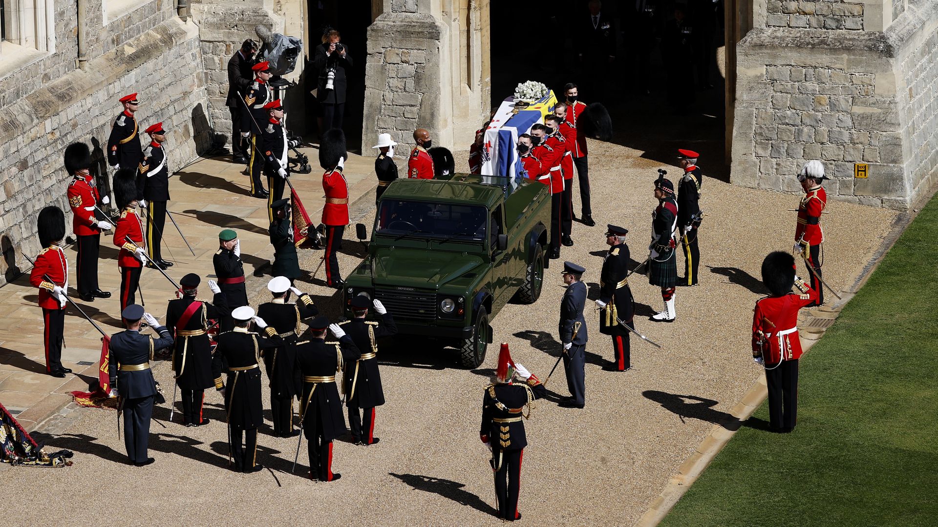 Picture of Prince Philip's coffin being carried to a land rover surrounded by officers