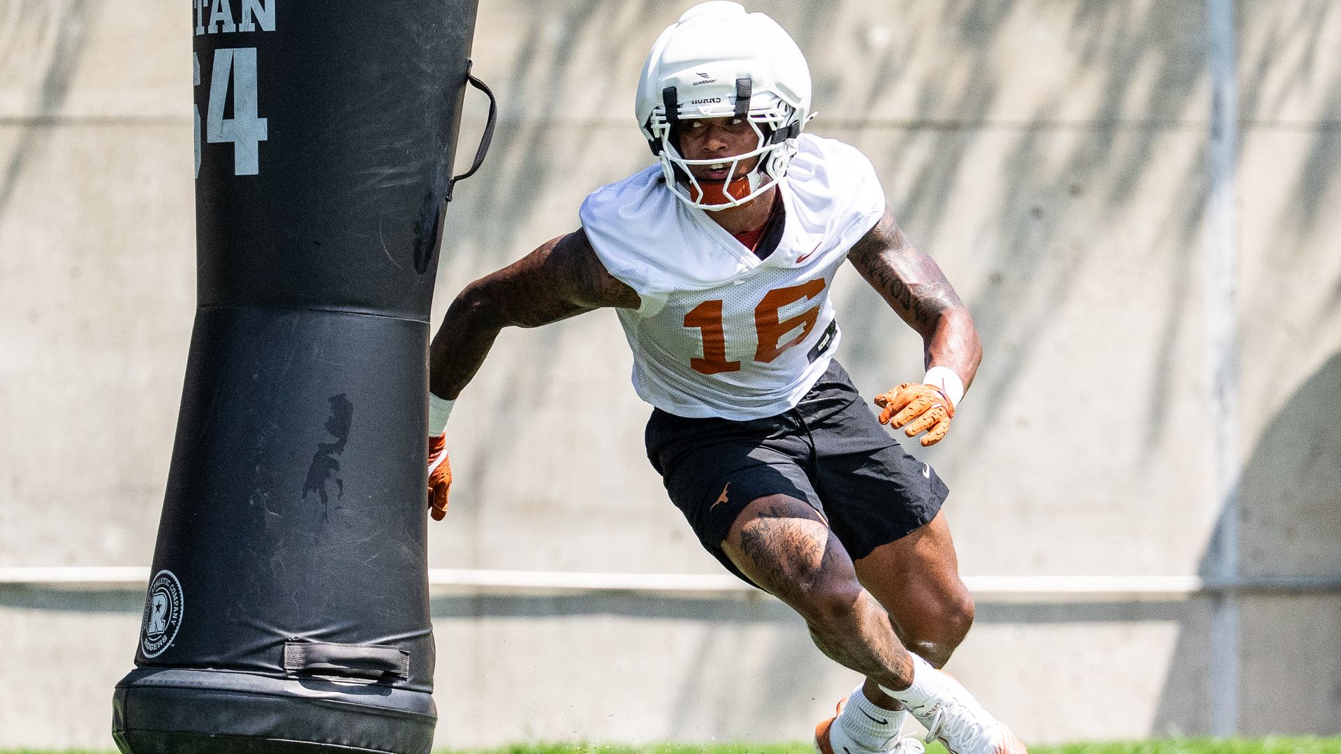 A Texas football player prepares to tackle a tackling dummy in practice.