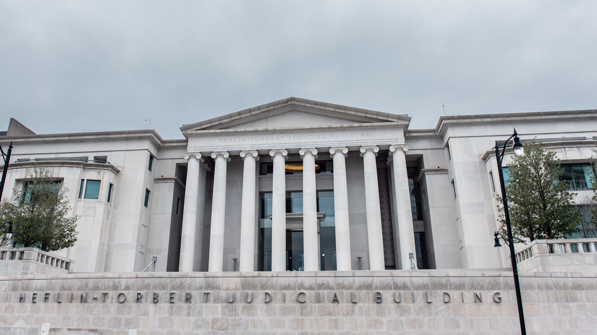 An image of the outside of the Alabama Supreme Court. The sky is cloudy. 