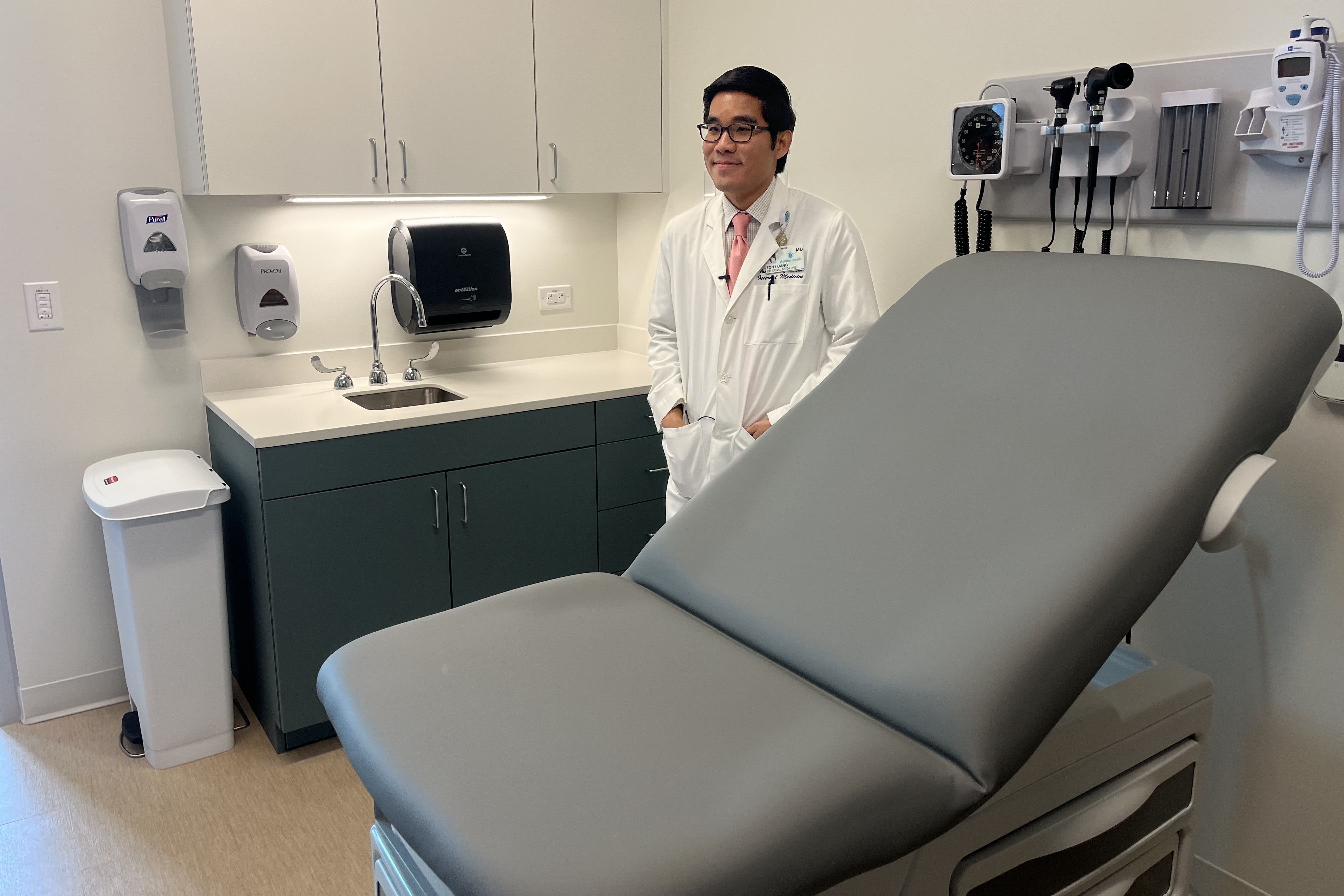 Anthony Dang stands in a doctor's room