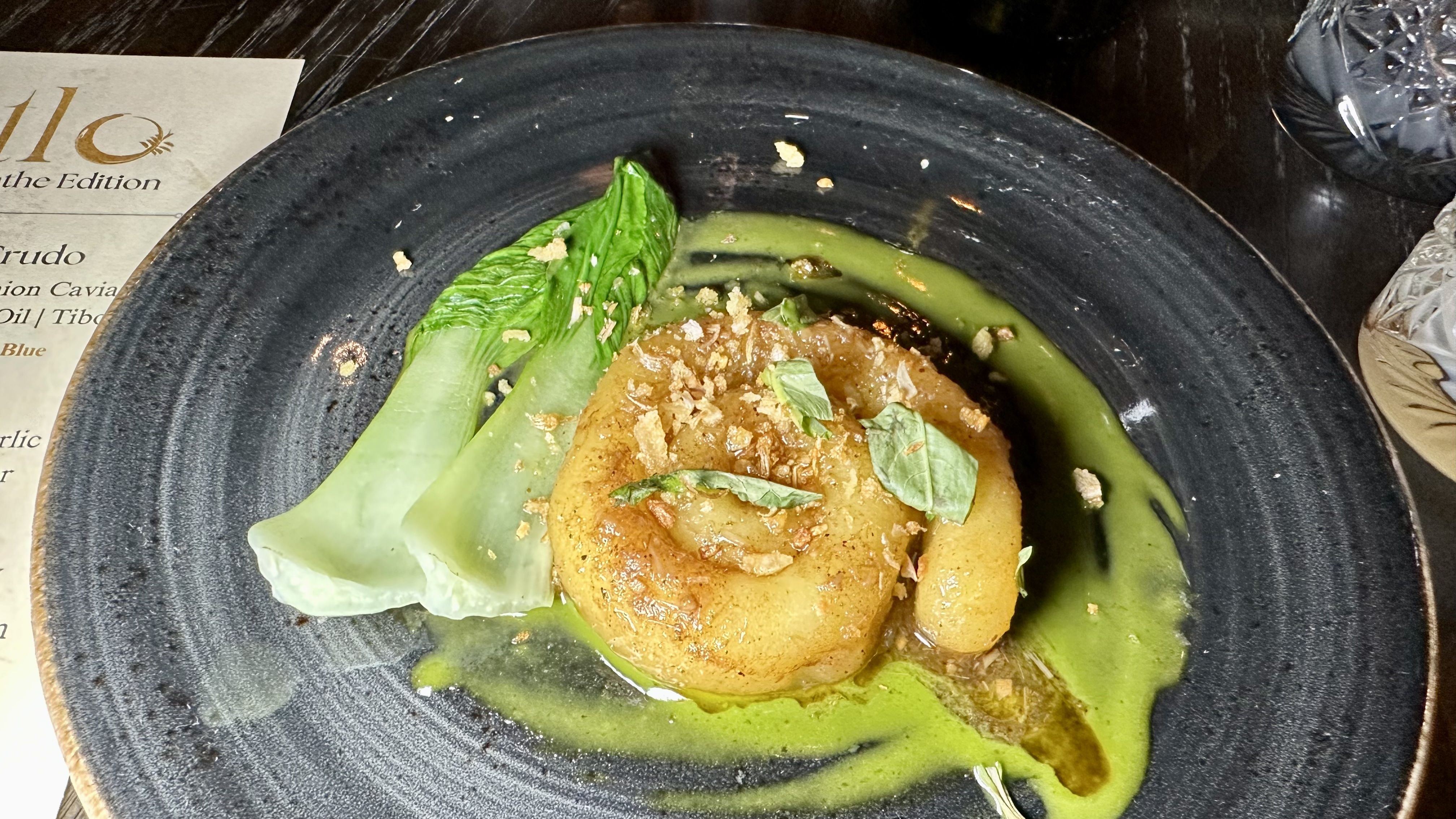 A noodle is curled up on a plate at Tatlo.