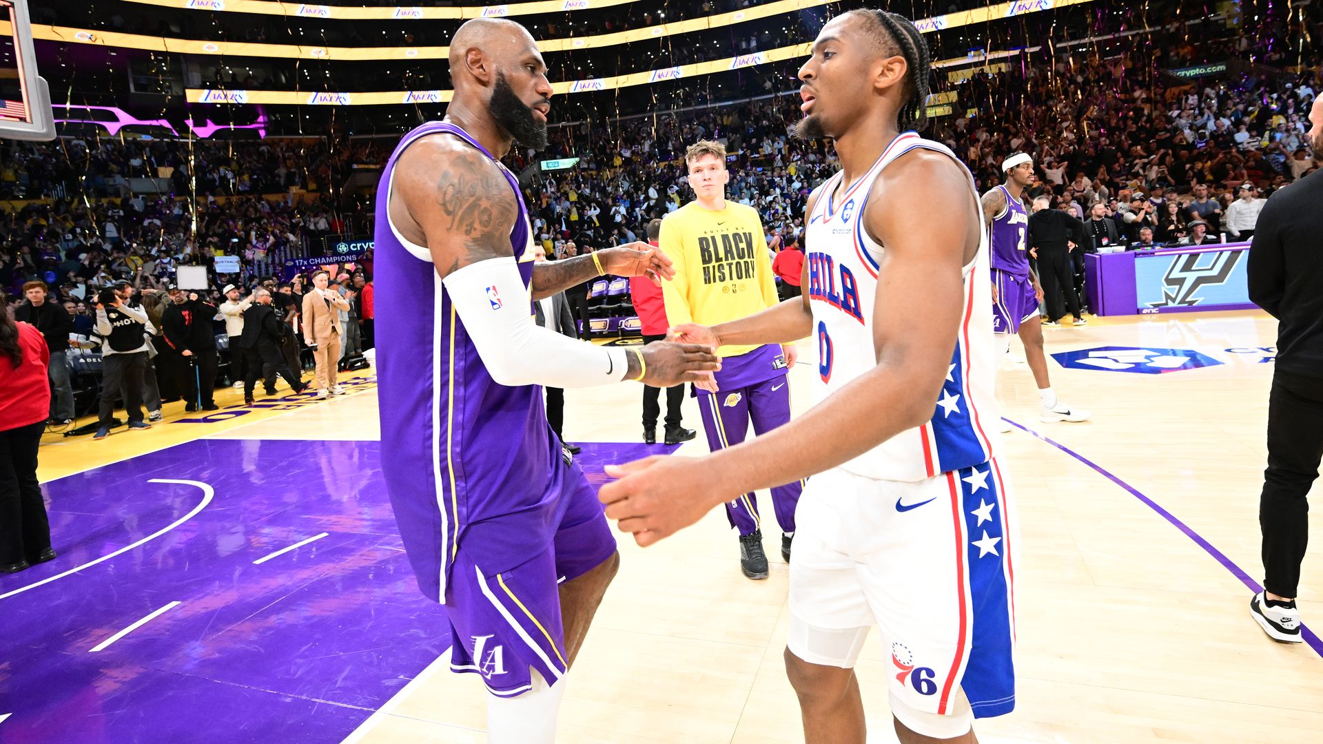 LeBron James and Tyrese Maxey shake hands after a game.