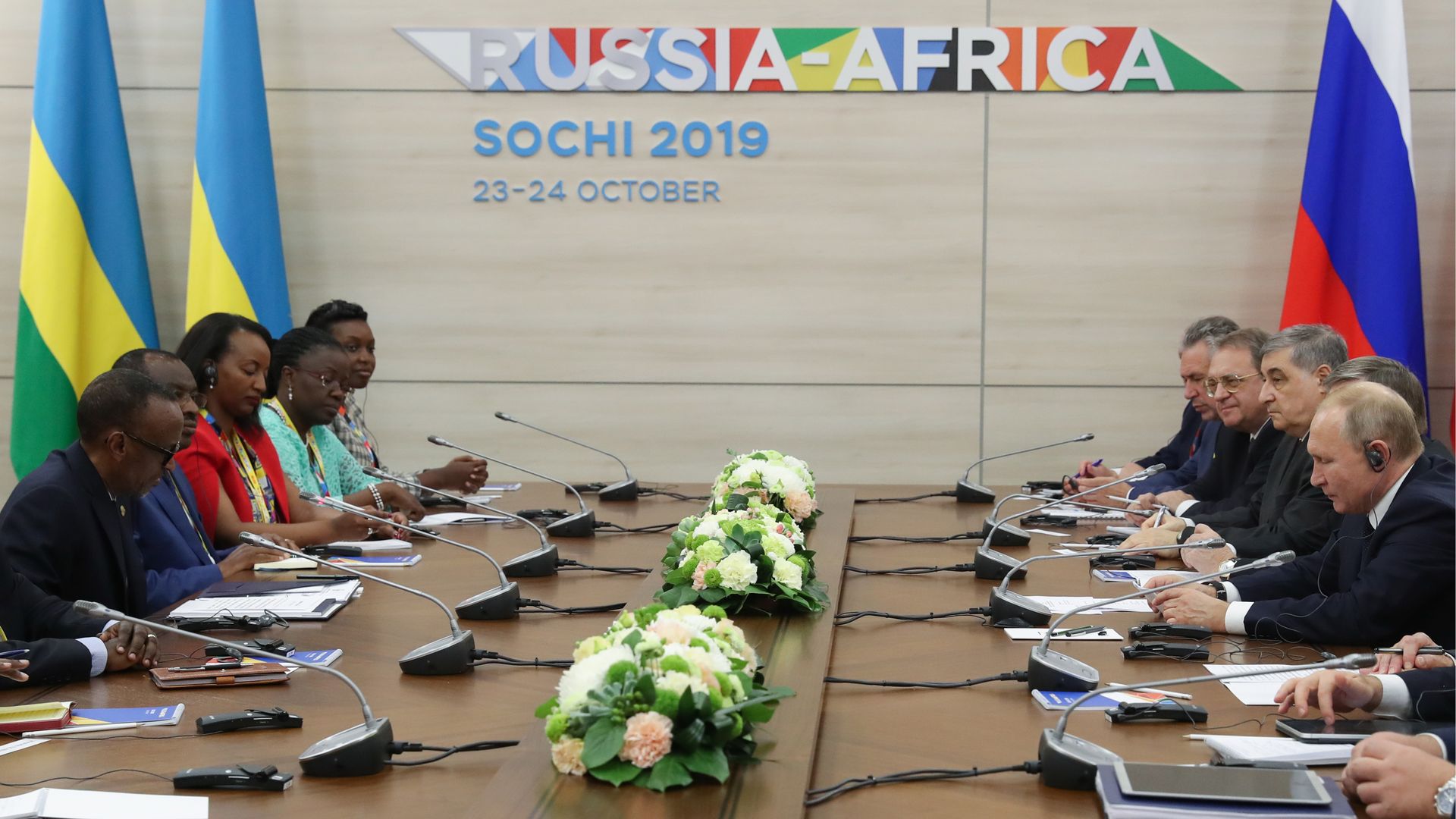 Putin, Kagame and fellow Russian and Rwandan officials seated across a conference table