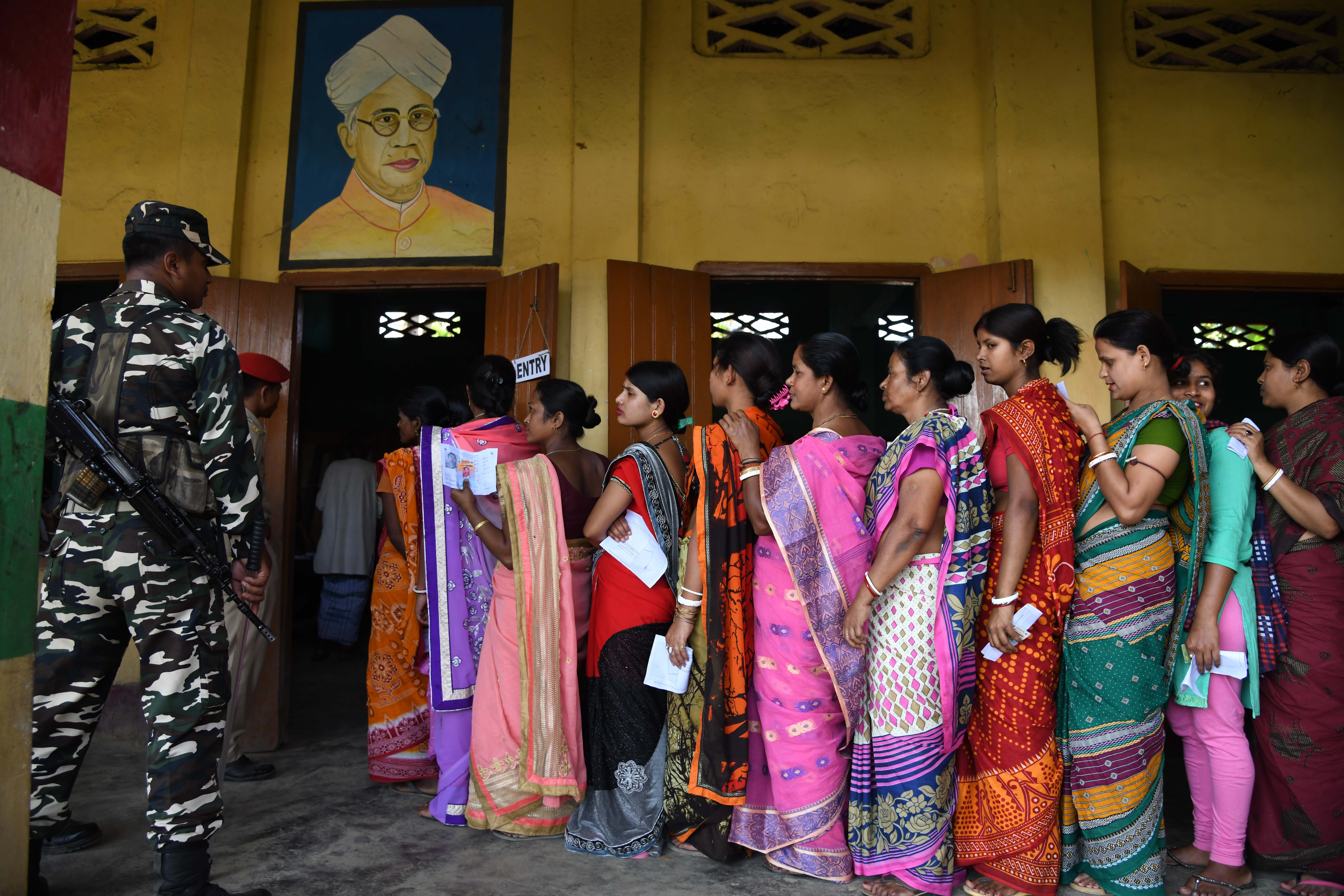  Indian voters queue to cast their votes at a polling station during India's general election in Amoni village, some 150 kms from Guwahati on April 11, 2019.