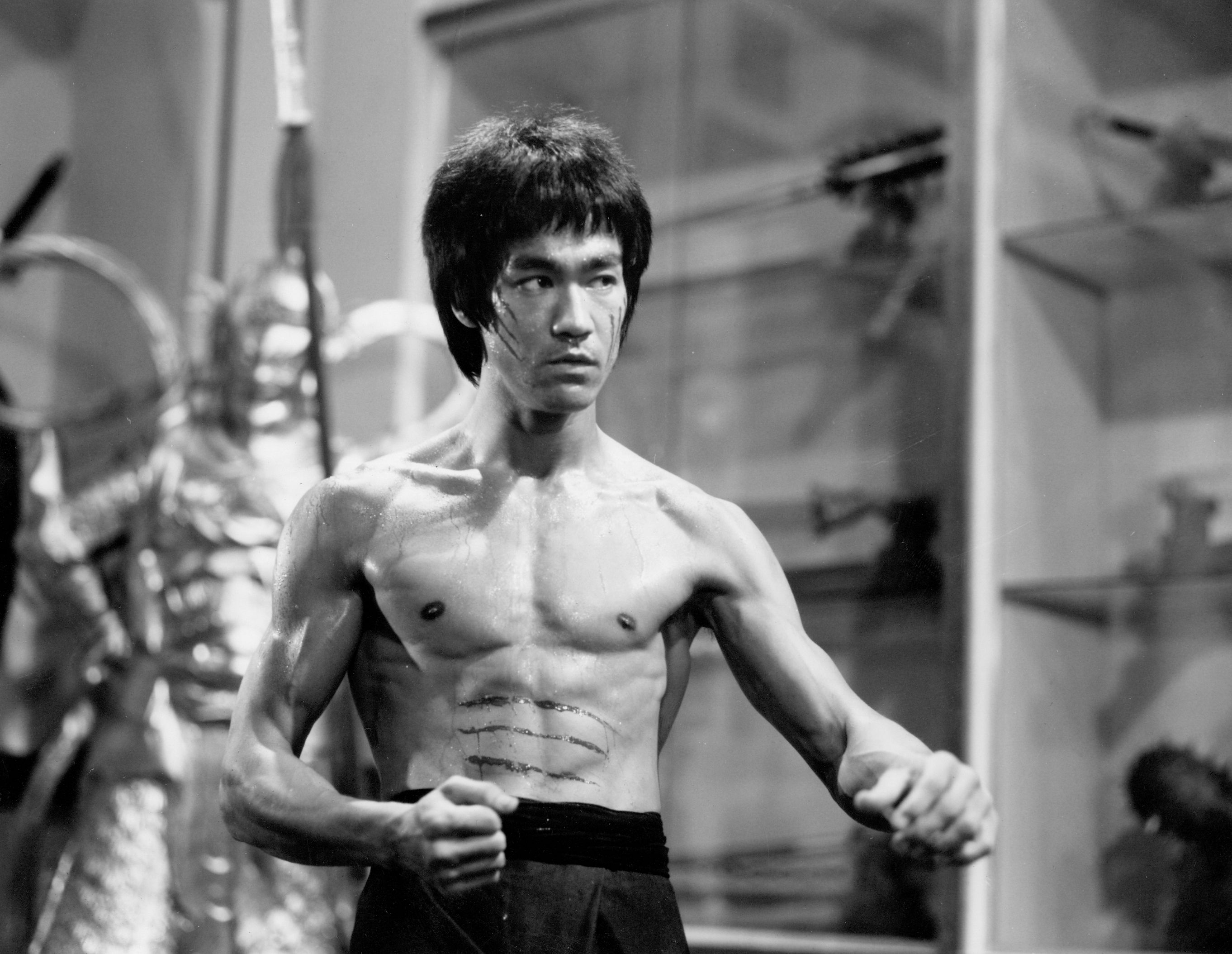 Photo of Bruce Lee holding his fists out while in a fighting stance