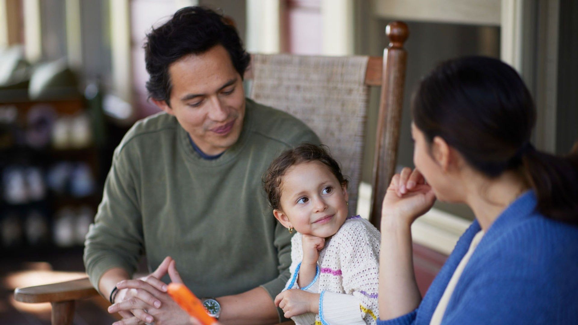 Parents and a young daughter sitting together.