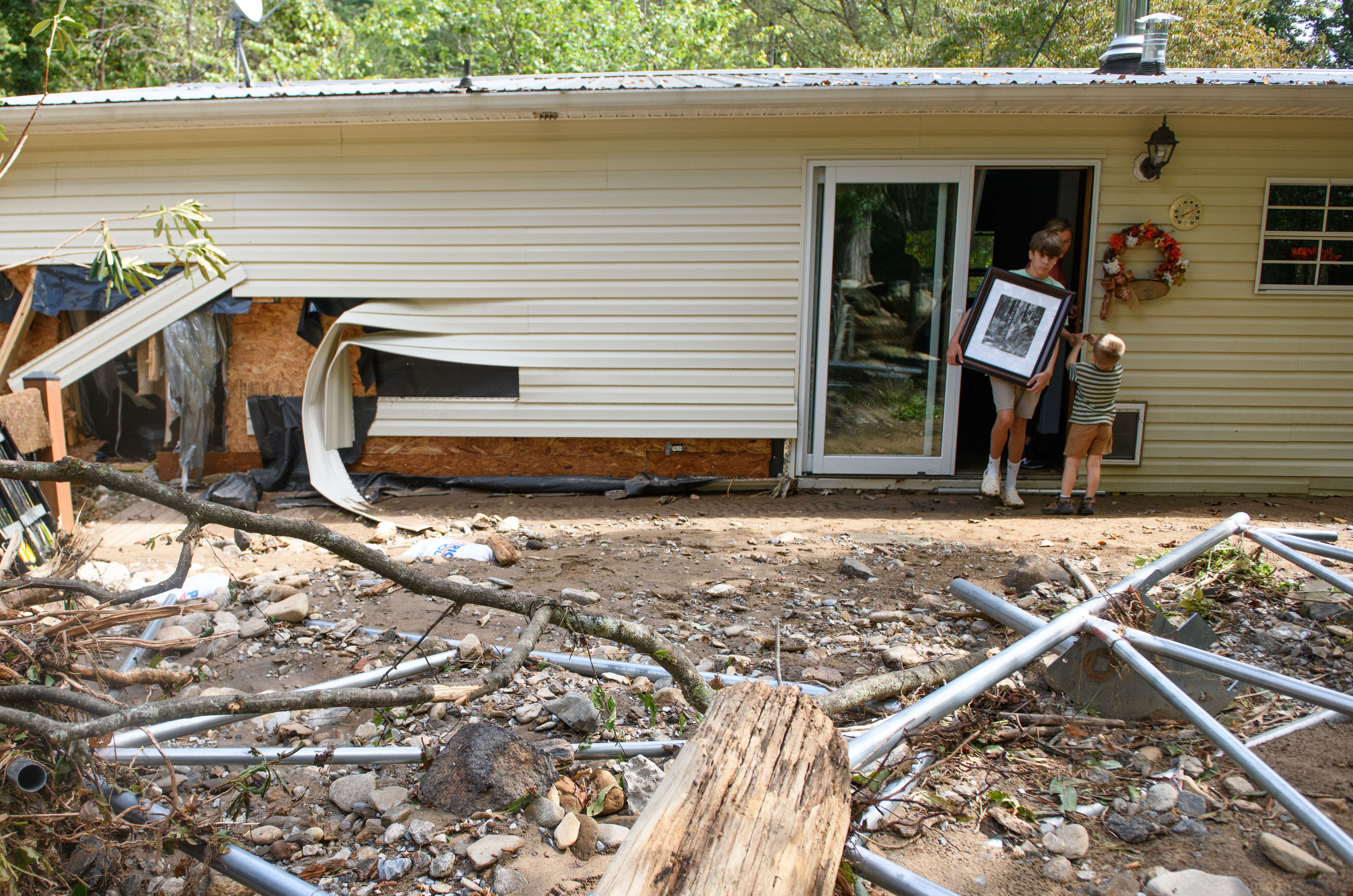 A 14-year-old boy salvages a picture from his grandparent's house in Old Fort, N.C., after Hurricane Helene.