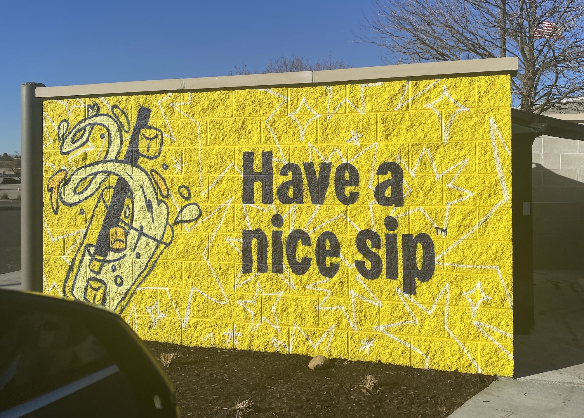 Yellow brick wall that reads: Have a nice sip.