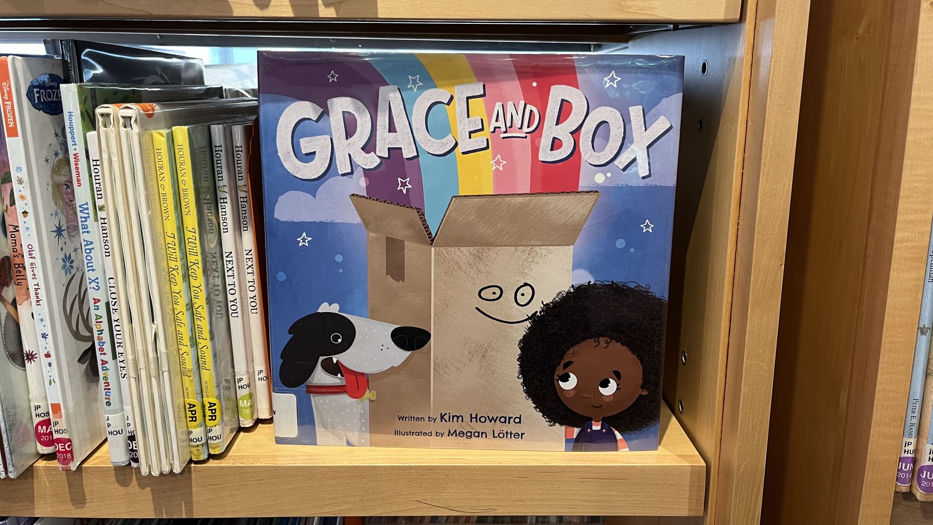 The cover of a book with a dog, a box and a little girl