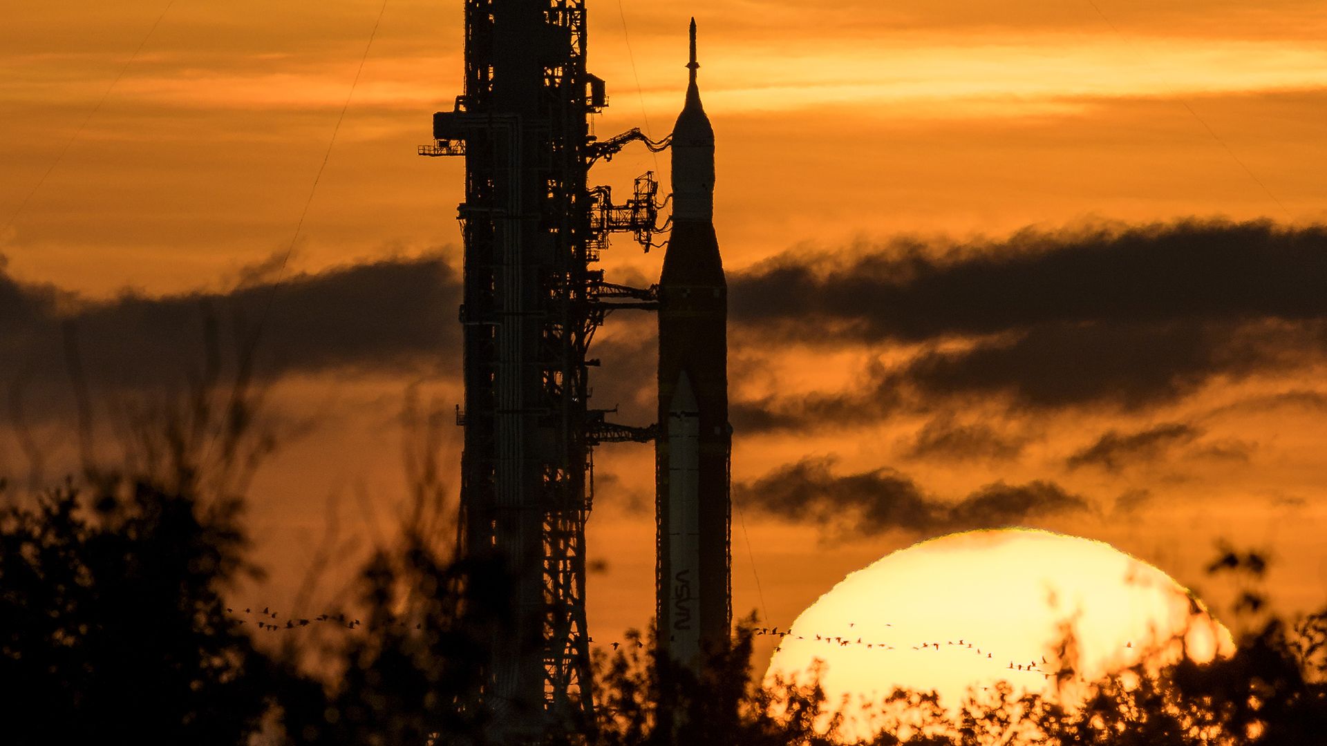 NASA's Space Launch System (SLS) rocket with the Orion spacecraft aboard is seen during sunrise atop a mobile launcher at Launch Pad 39B as preparations for launch continue