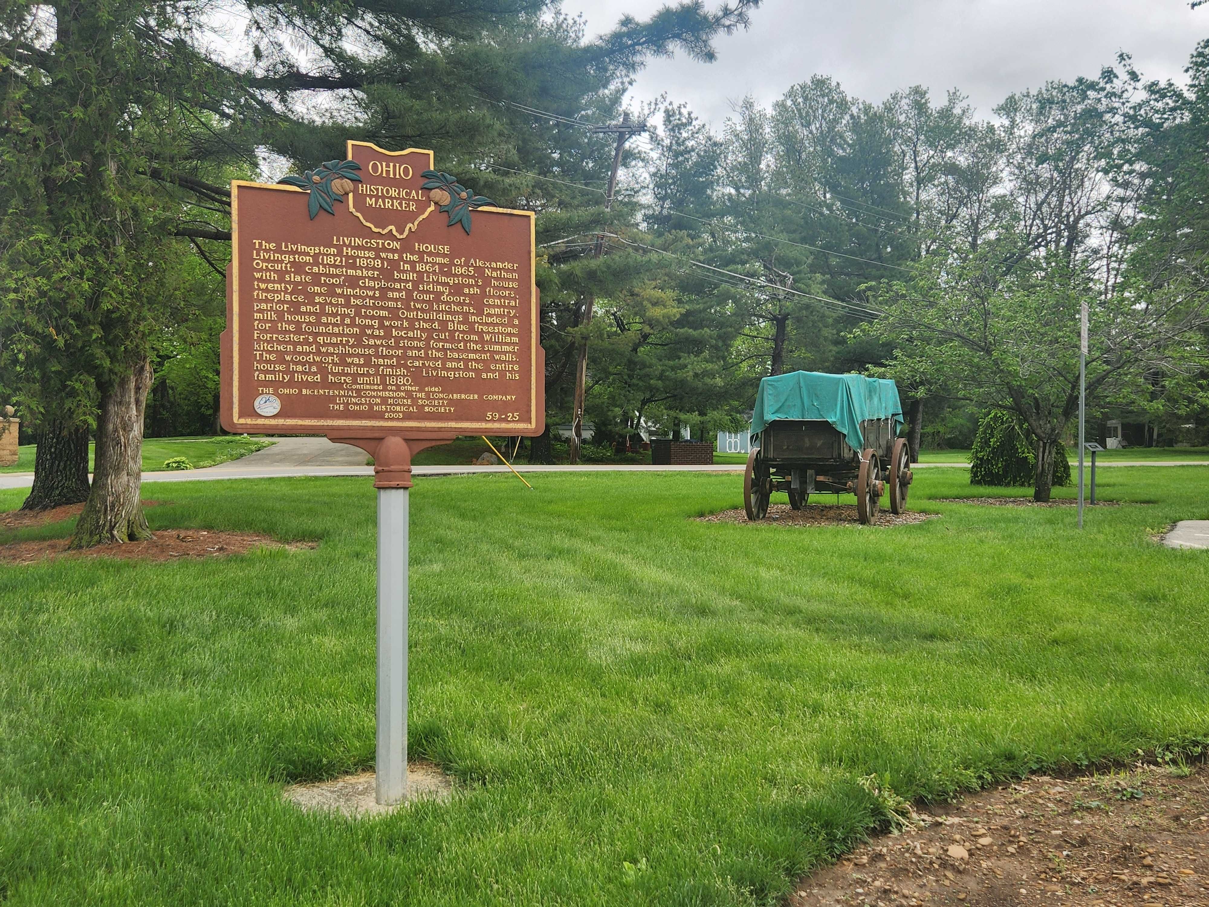 A historical marker for the Livingston House and an old stagecoach. 