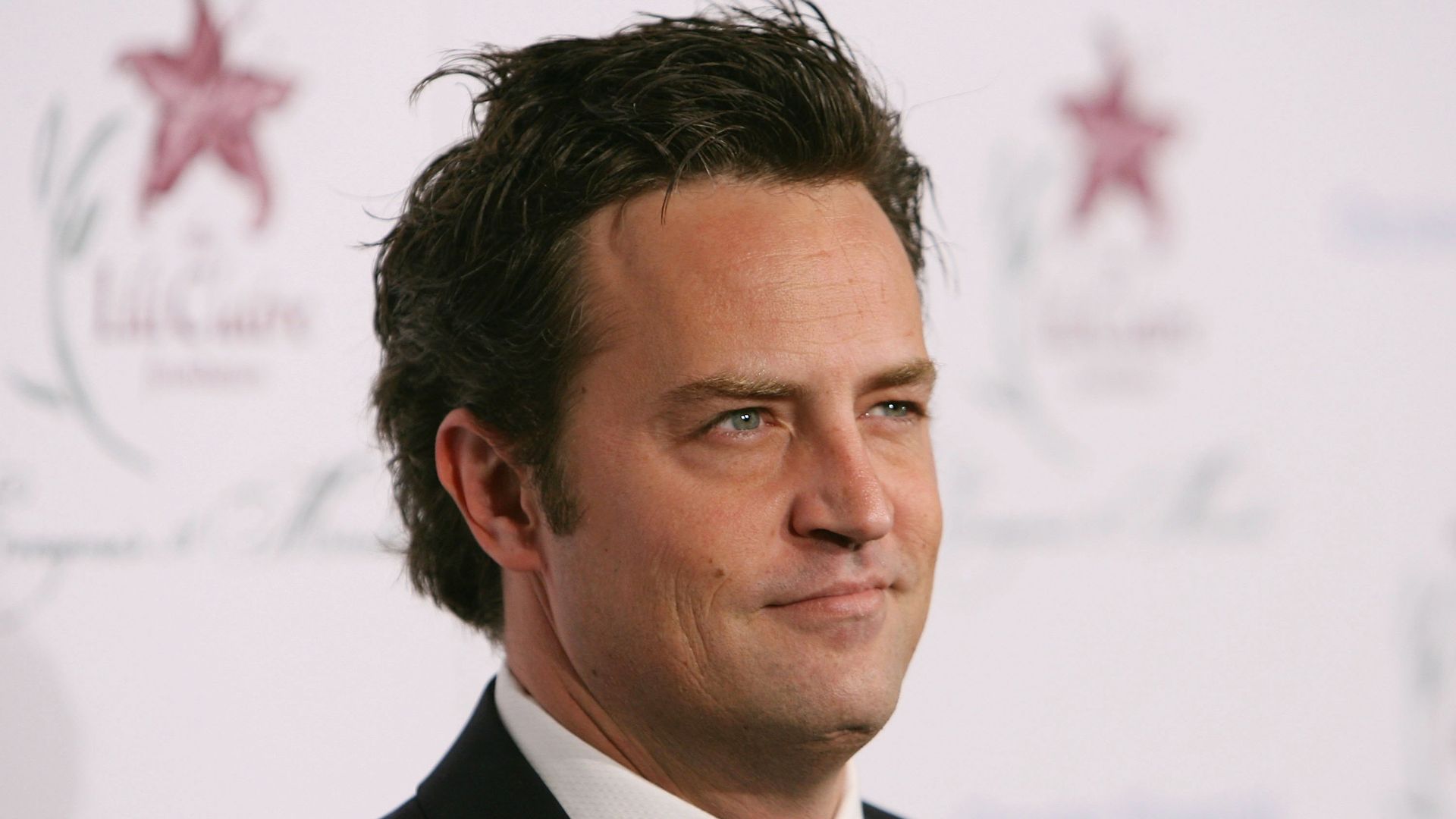 Matthew Perry walks the carpet at an event.