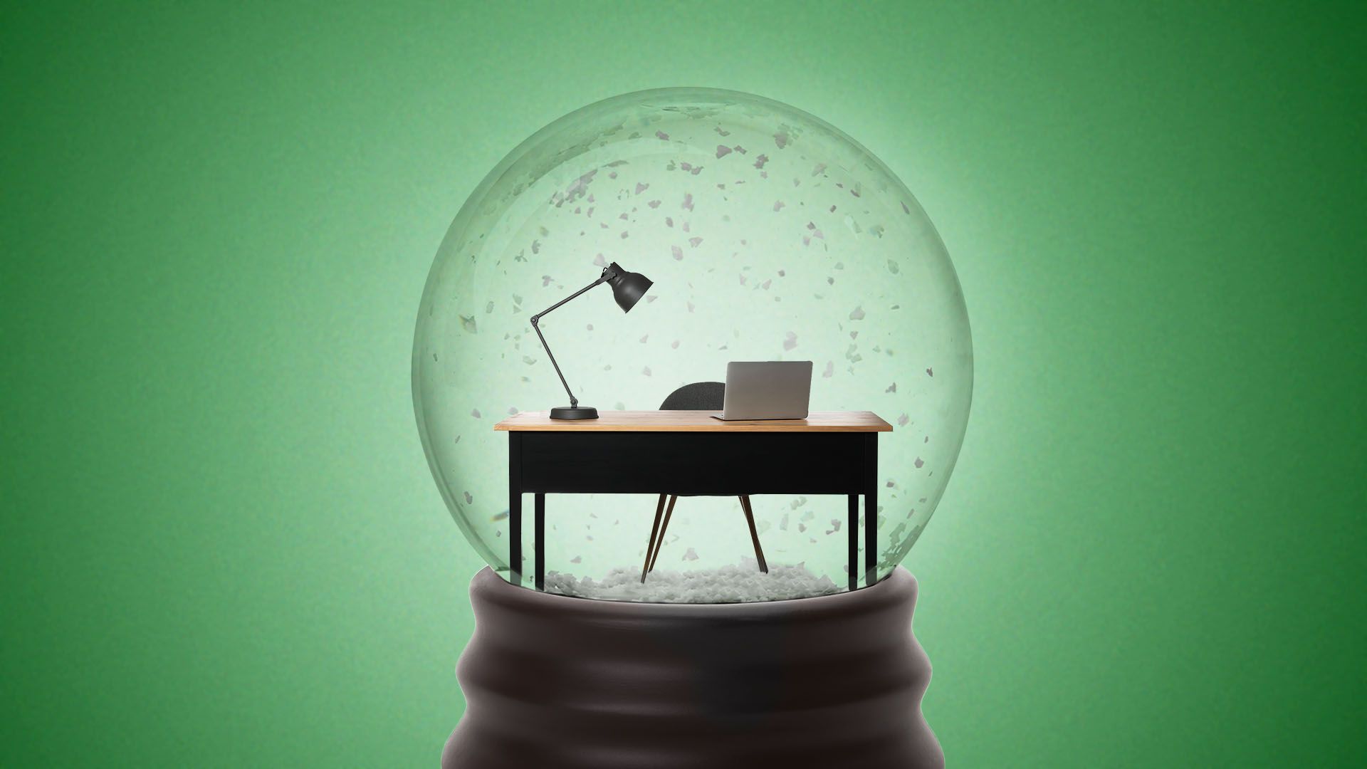 a snowglobe containing an office desk and computer setup 