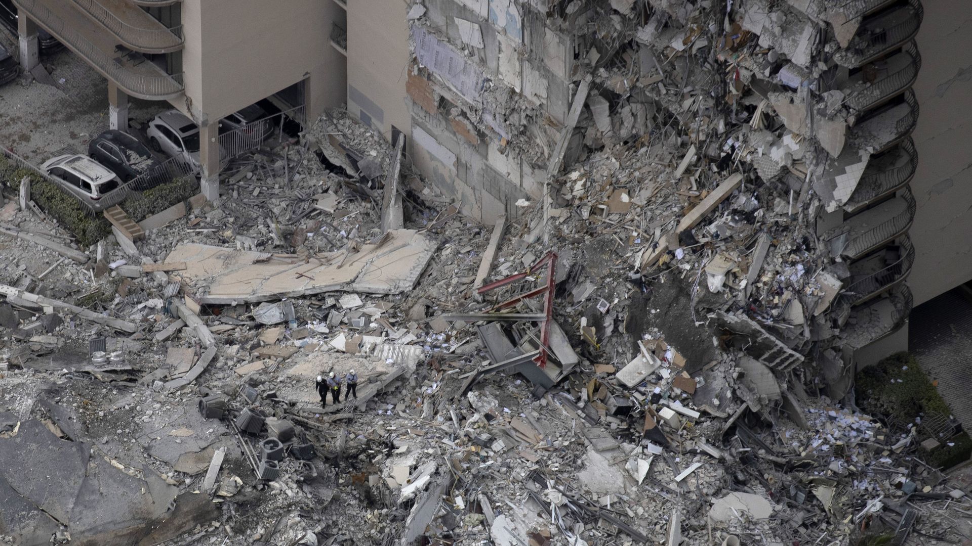 Search and rescue personnel with a K9 unit work in the rubble of a 12-story residential tower that partially collapsed on June 24, 2021 in Surfside, Florida.