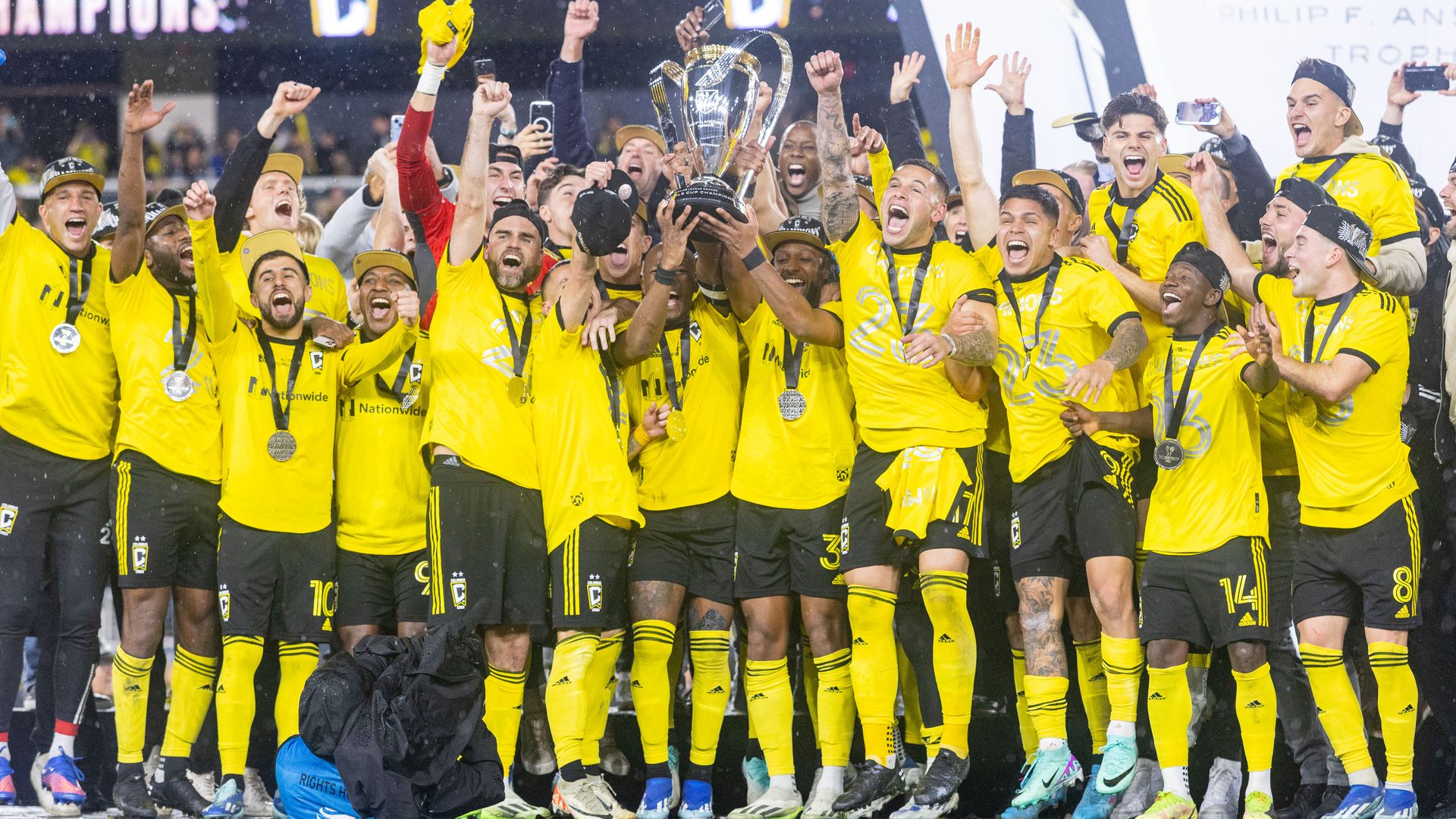 Columbus Crew players hold up a championship trophy.