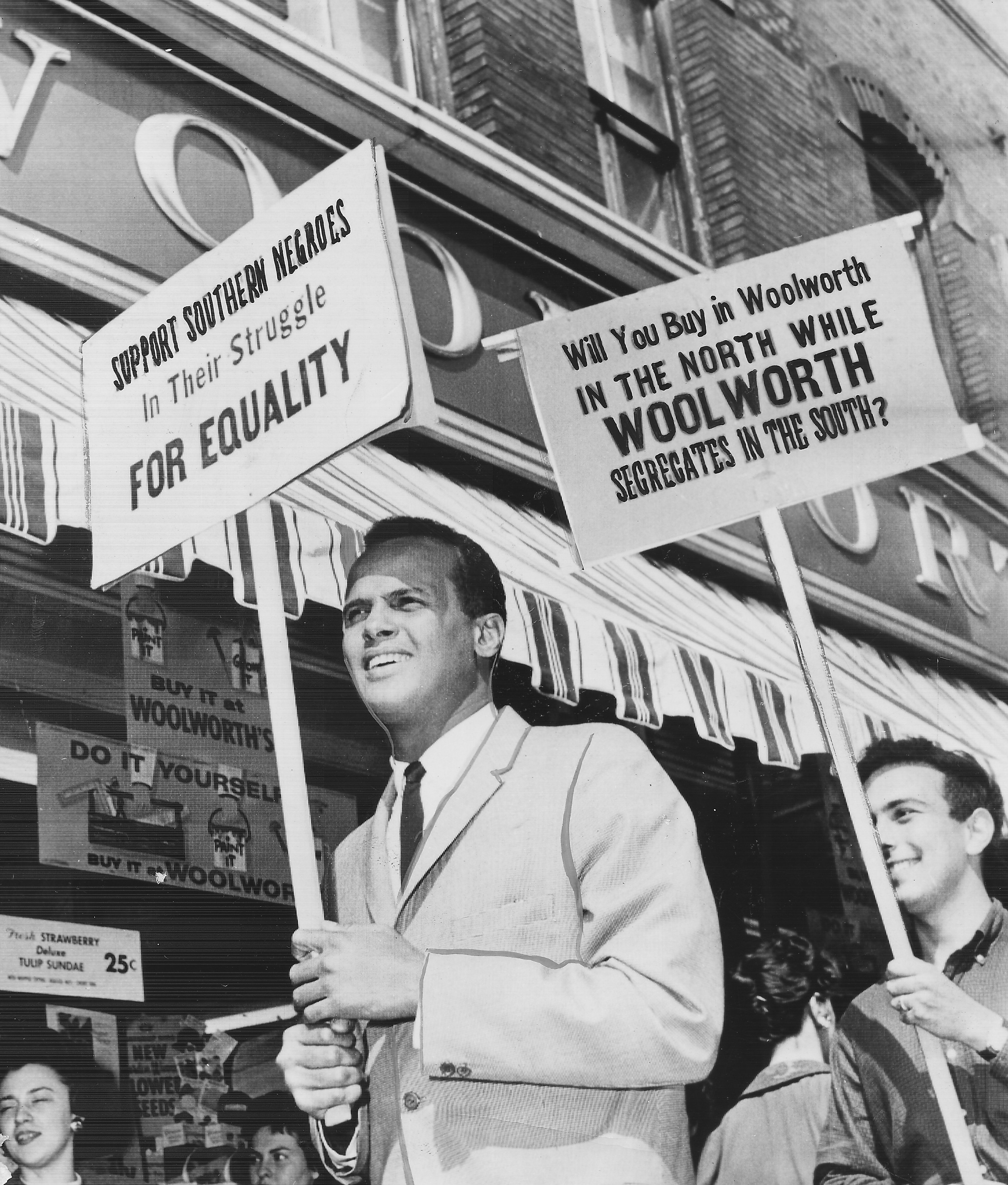 Harry Belafonte holding signs and marching during a protest against segregation by Woolworths department stores, 1960. 