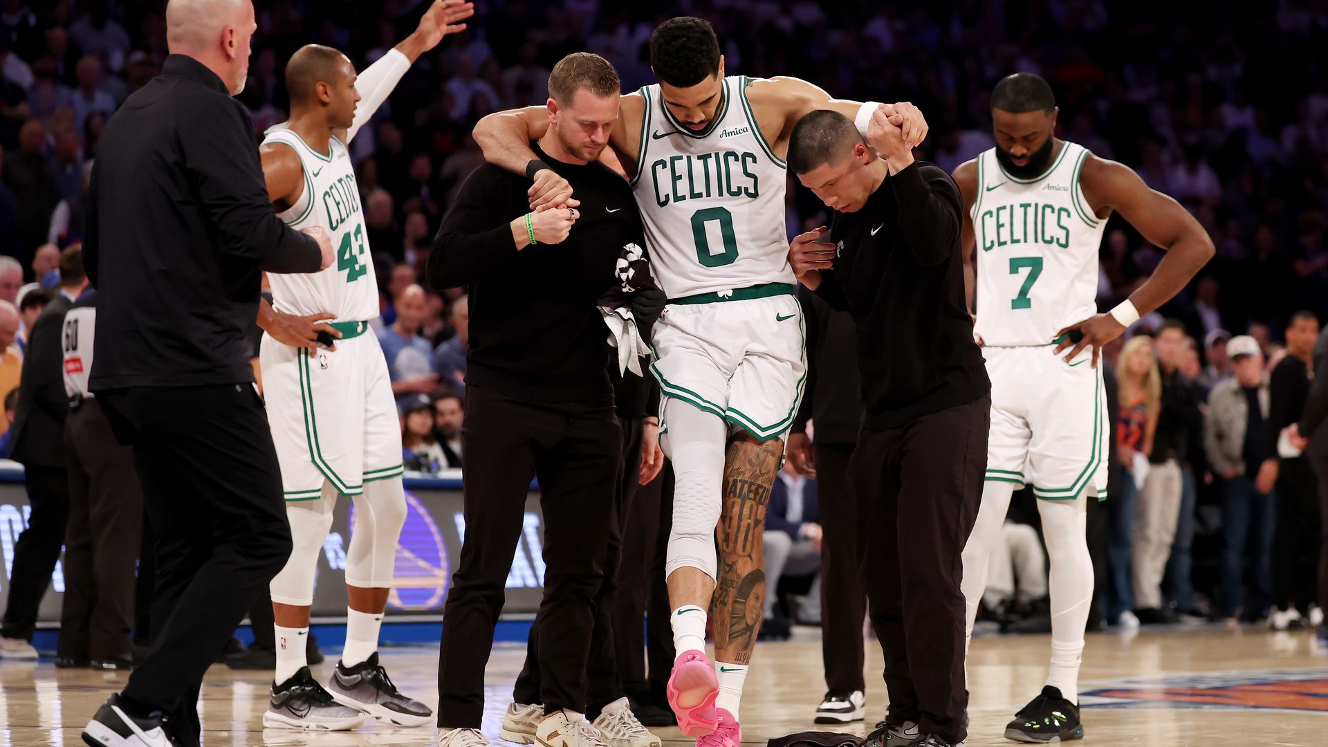 Jayson Tatum #0 of the Boston Celtics is assisted off court after being injured against the New York Knicks during the fourth quarter in Game Four of the Eastern Conference Second Round NBA Playoffs .