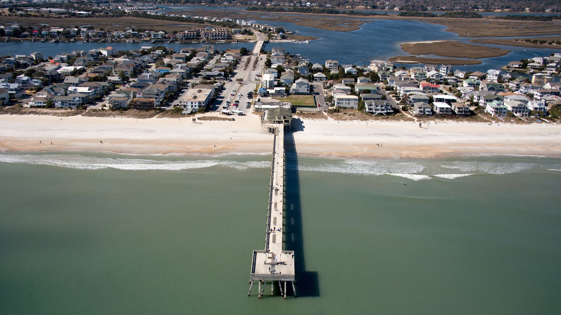 An aerial view of a pier and buildings along the Atlantic Ocean shoreline on a clear day in February 2016 in Wrightsville Beach, North Carolina.