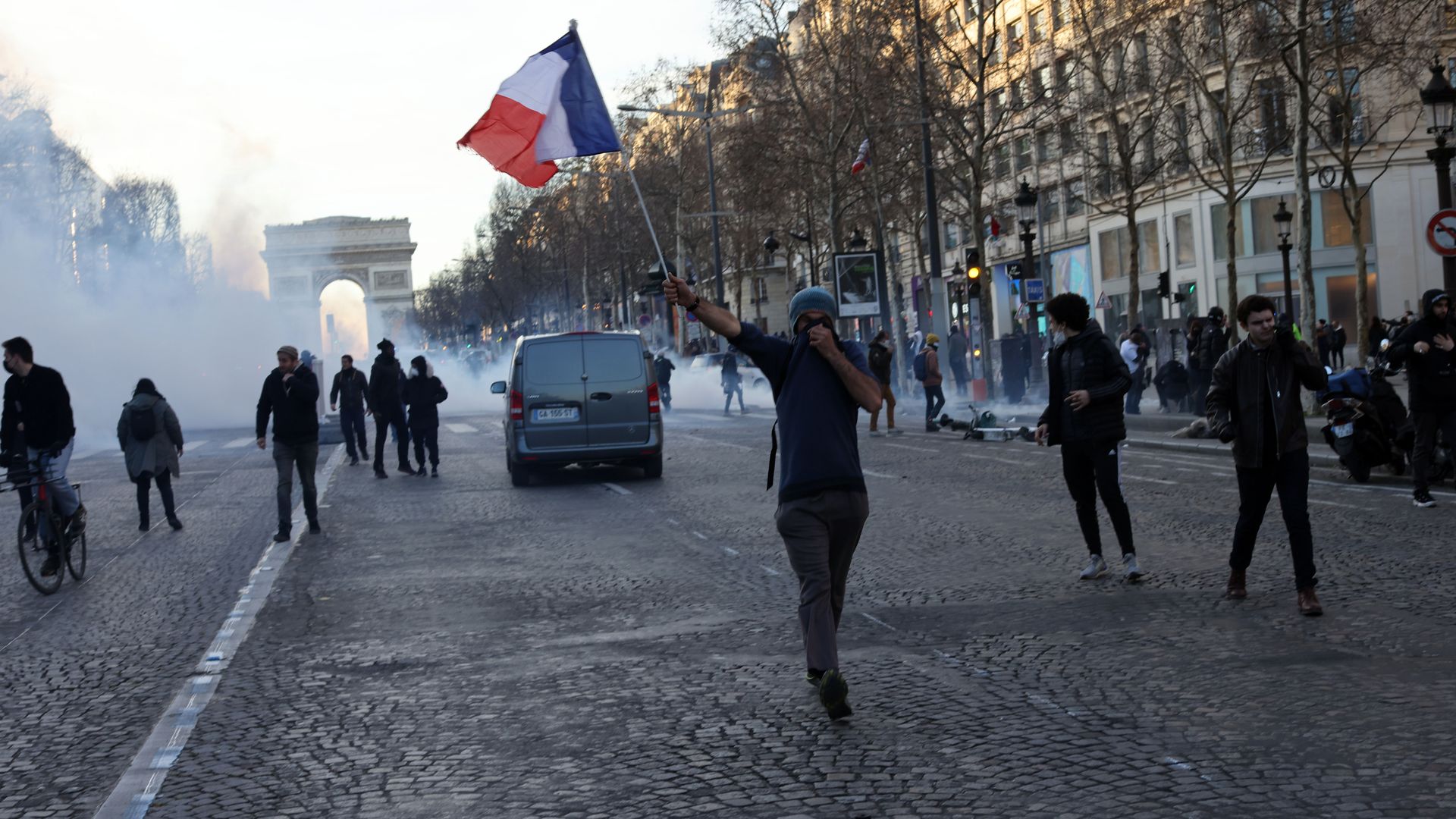 Demonstraters wave French flags and yellow vests on the Champs Elysees in Paris on February 12, 2022.