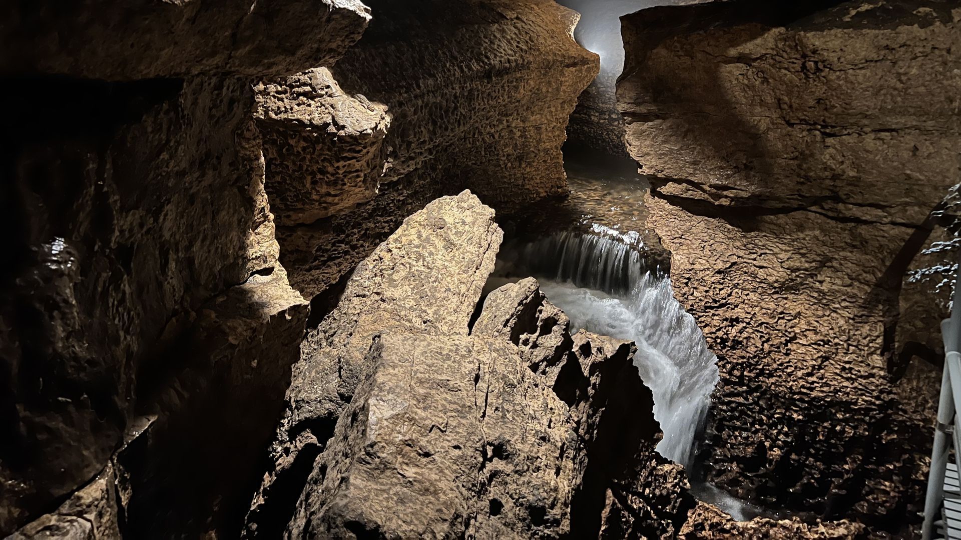 A small waterfall flows through a cave