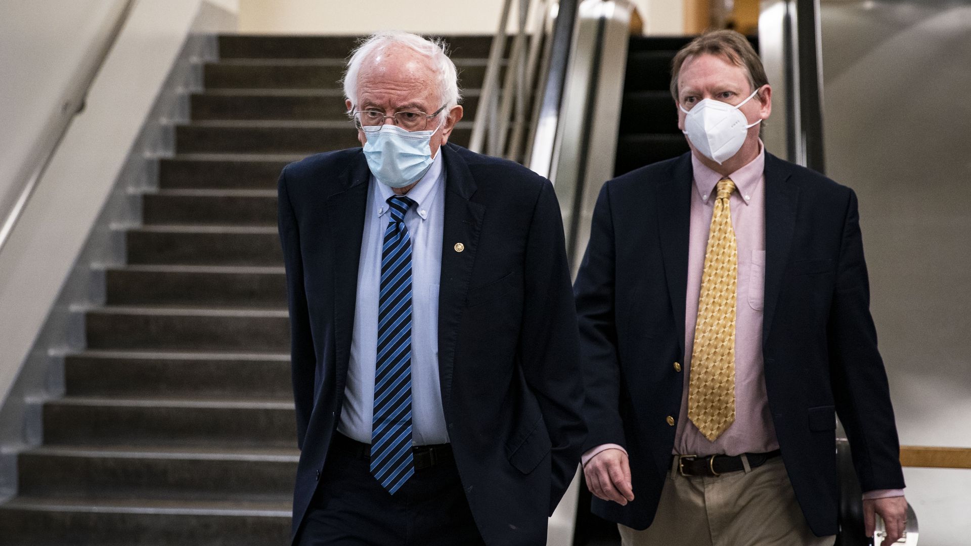 Bernie Sanders walks with an aide