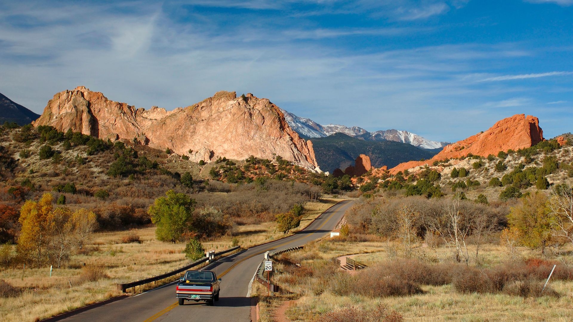 A pickup truck drives on a road near The Garden of the Gods in Colorado Springs, Colorado. 